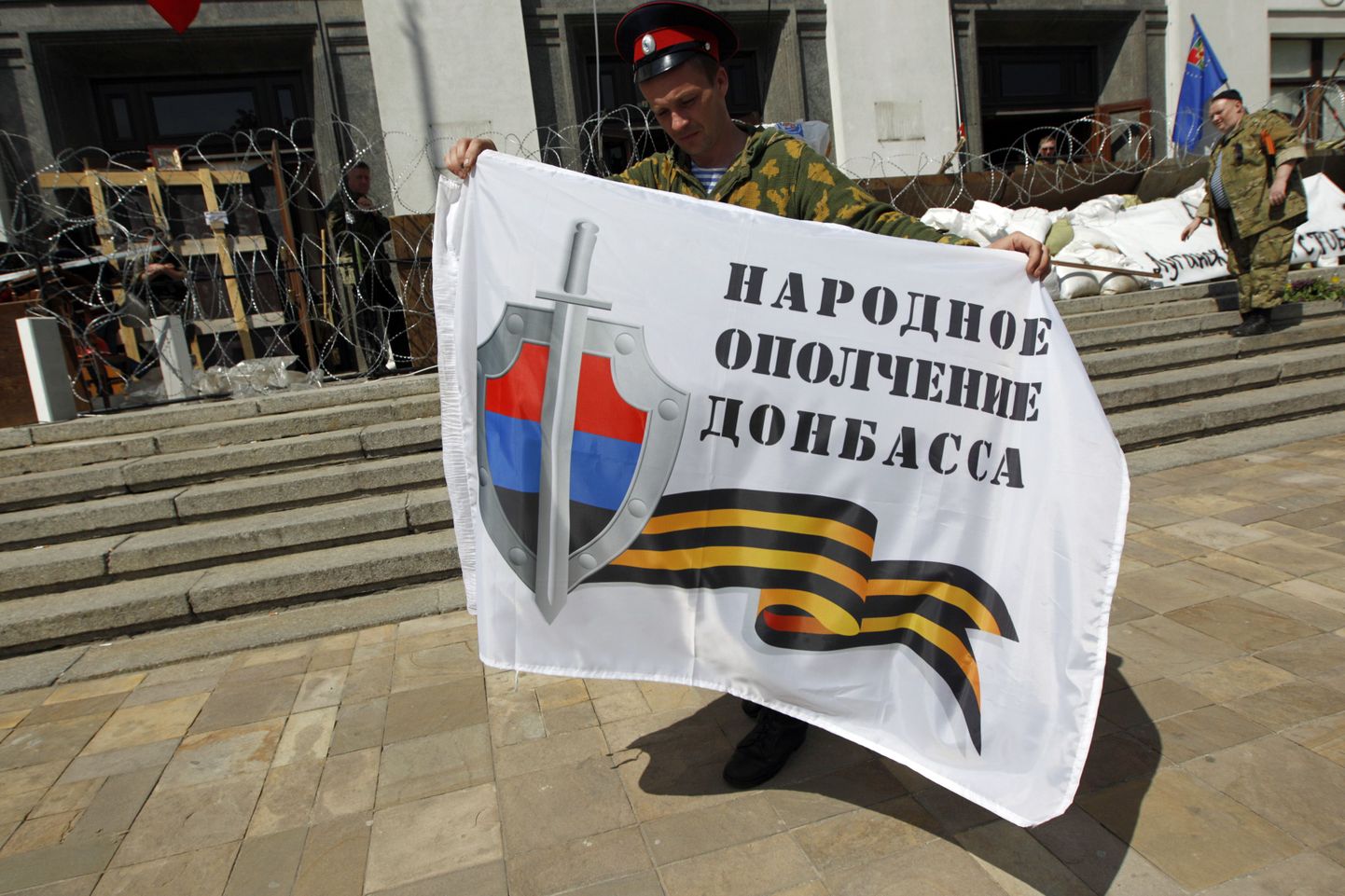 Venemeelne separatist Luganski oblastivalitsuse hoone ees kangagaga, millel on kirjutatud Donbassi rahvuslik vastupanuliikumine.