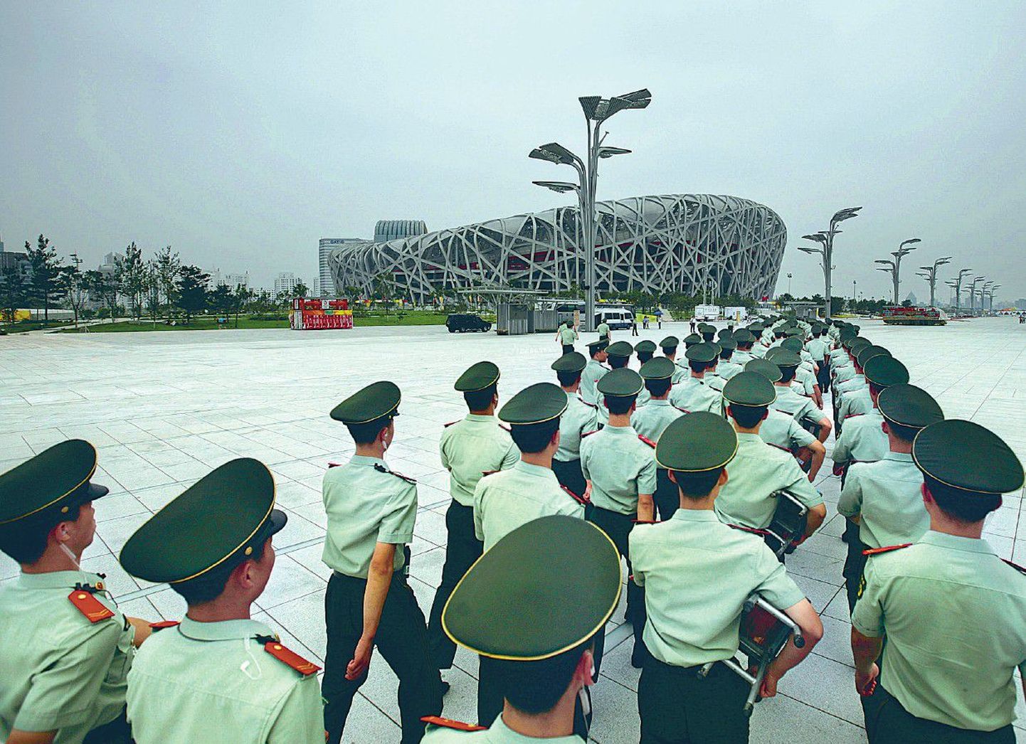Hiina politseinikud marsivad 5,7 miljardit dollarit maksma läinud olümpiastaadioni ehk Linnupesa ees.