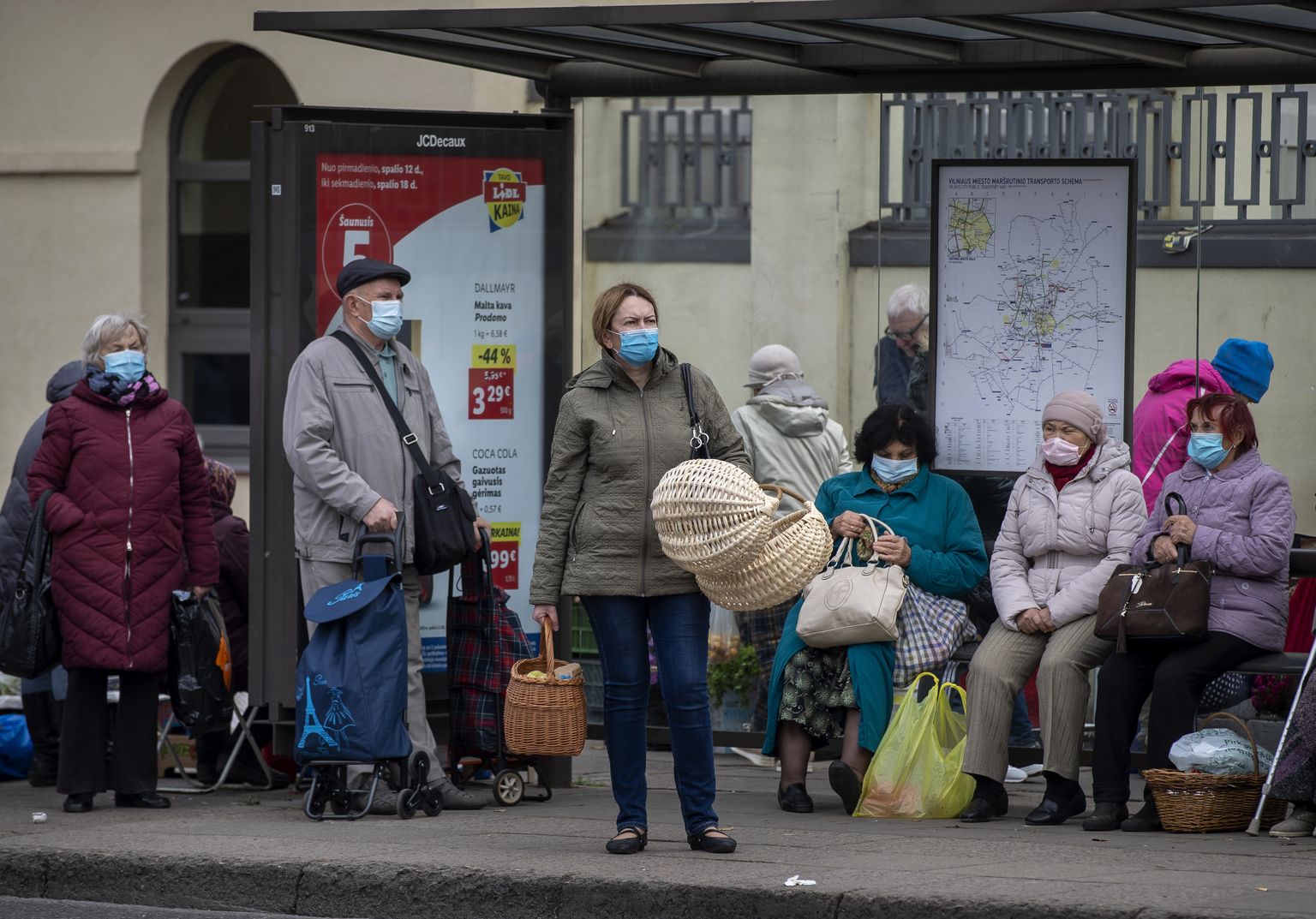 Cilvēki Viļņā sabiedriskā transporta pieturā