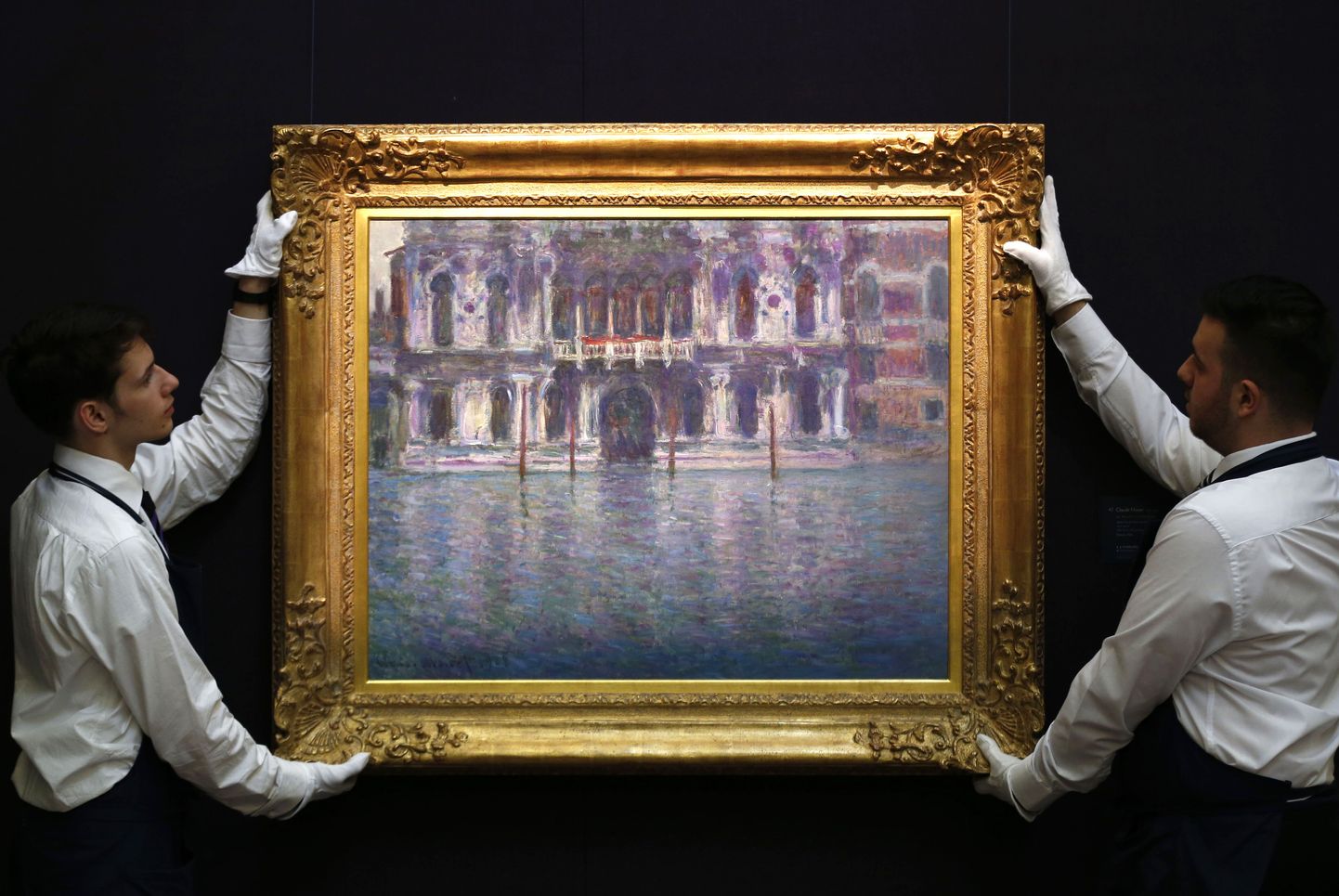 Oksjonimaja Sotheby's töötajad hoiavad käes Claude Monet' maali «Le Palais Contarini», mille kunstnik maalis Veneetsias 1908. aastal.