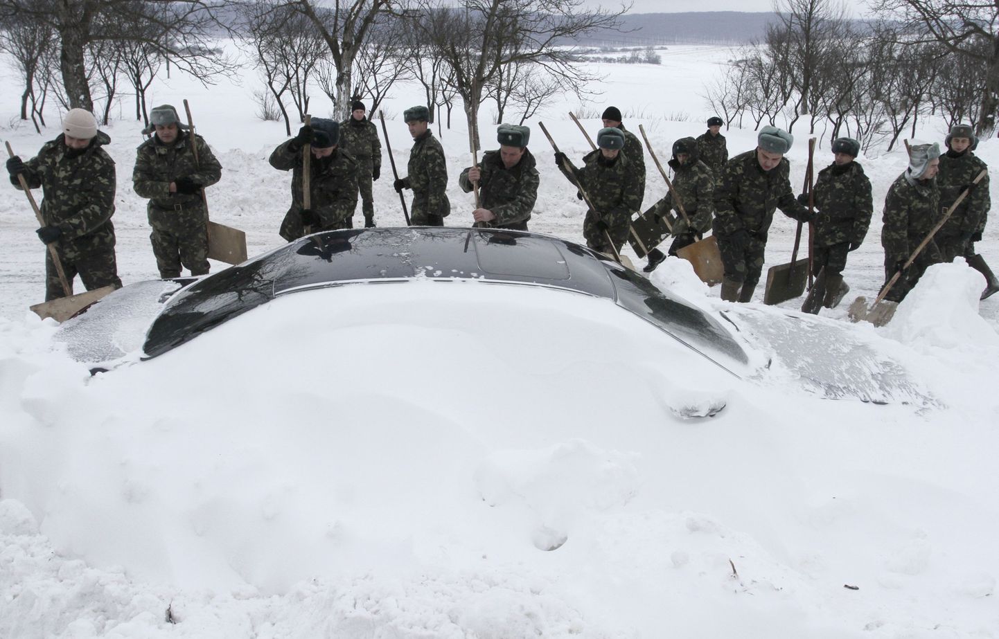 Ukraina hädaabitöölised riigi lääneosas asuvas Brodõs autot lume alt välja kaevamas.
