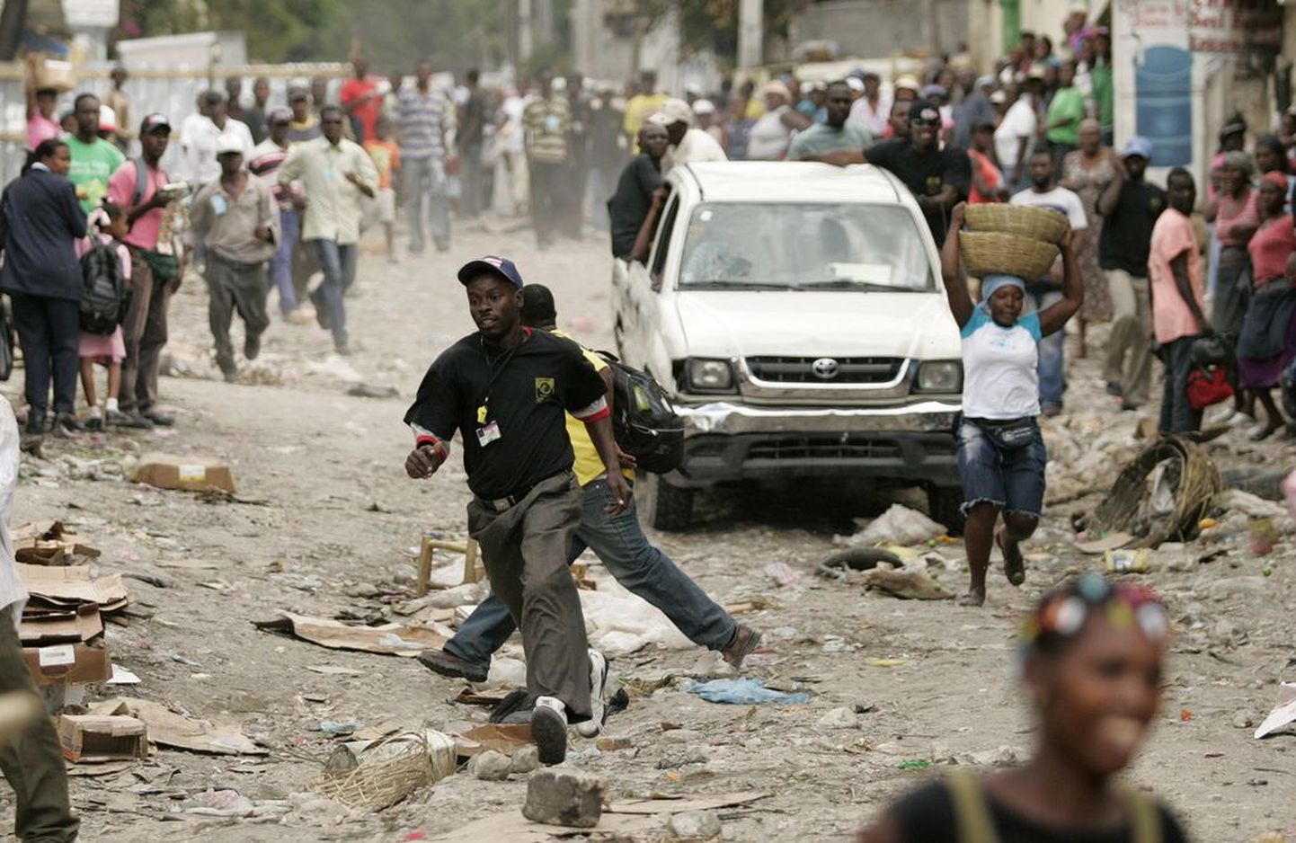 Haiitilased jooksmas politsei eest pakku tänavaturul saareriigi pealinnas Port-au-Prince'is.