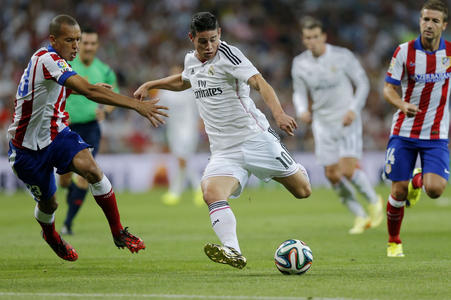 Madridi Reali väravakütt James Rodriguez ja Madridi Atletico Joao Miranda palli taga ajamas.