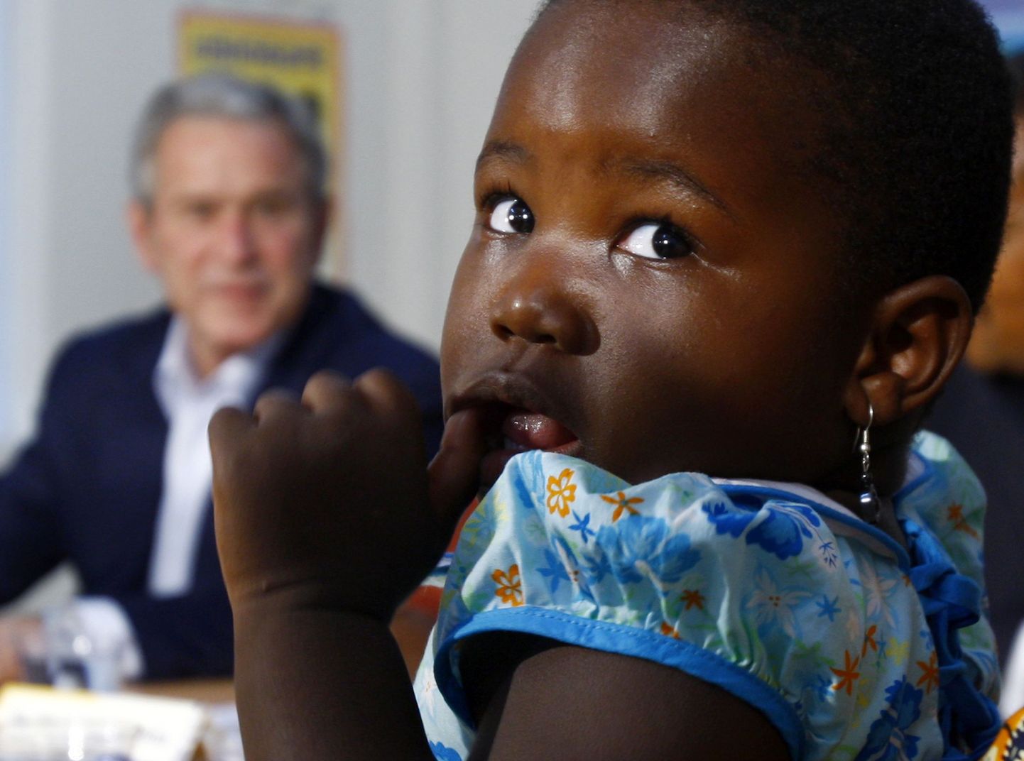 USA president George W. Bush vaatamas kolmeaastast Tansaania tüdrukut, kelle ema on HIV-positiivne.