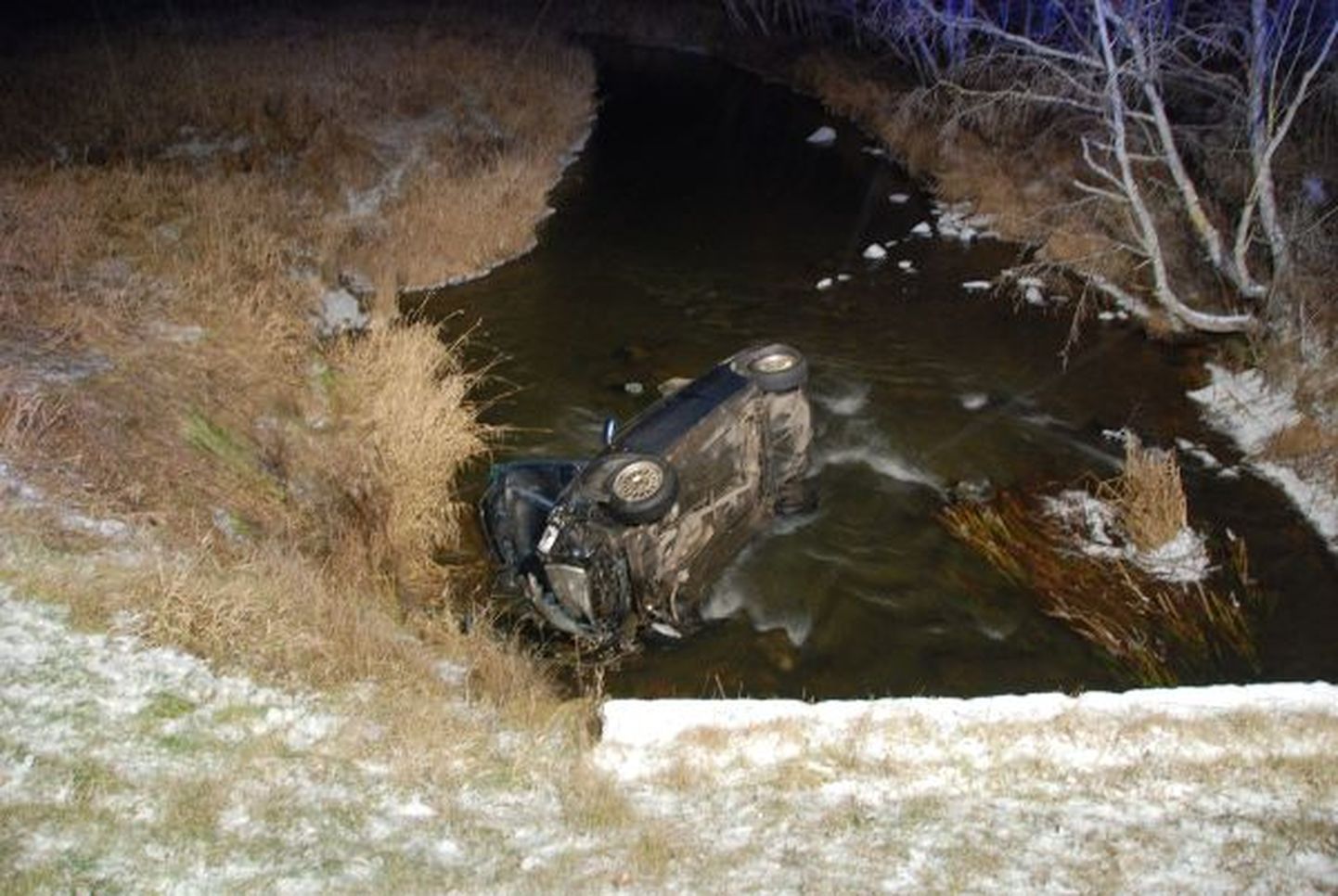 Liiklusõnnetus Tartumaal Reolas, kus juhitavuse kaotanud auto paikus jõkke.