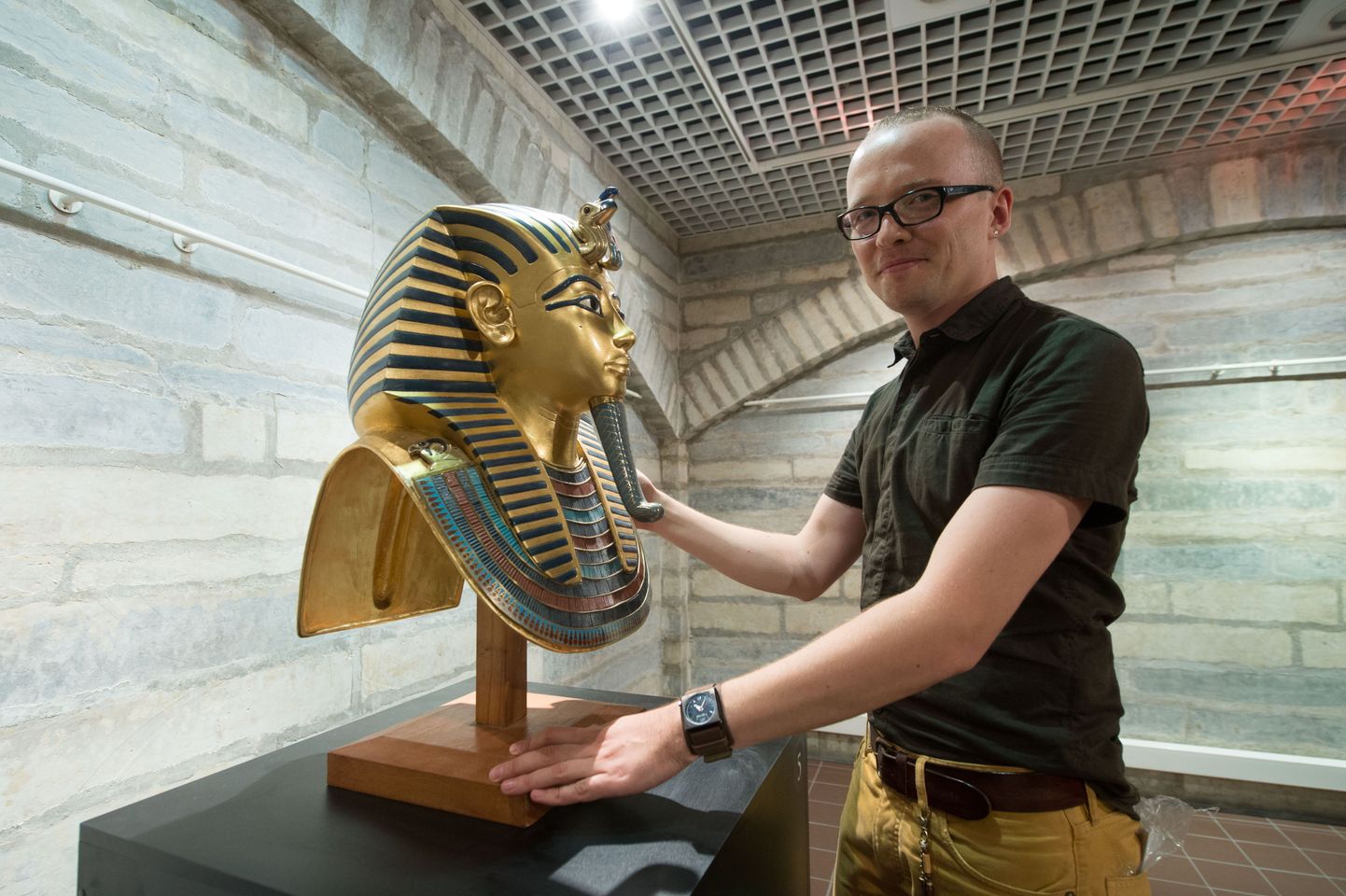 За несколько минут перед открытием выставки служитель наводит лоск на копию погребальной маски Тутанхамона.