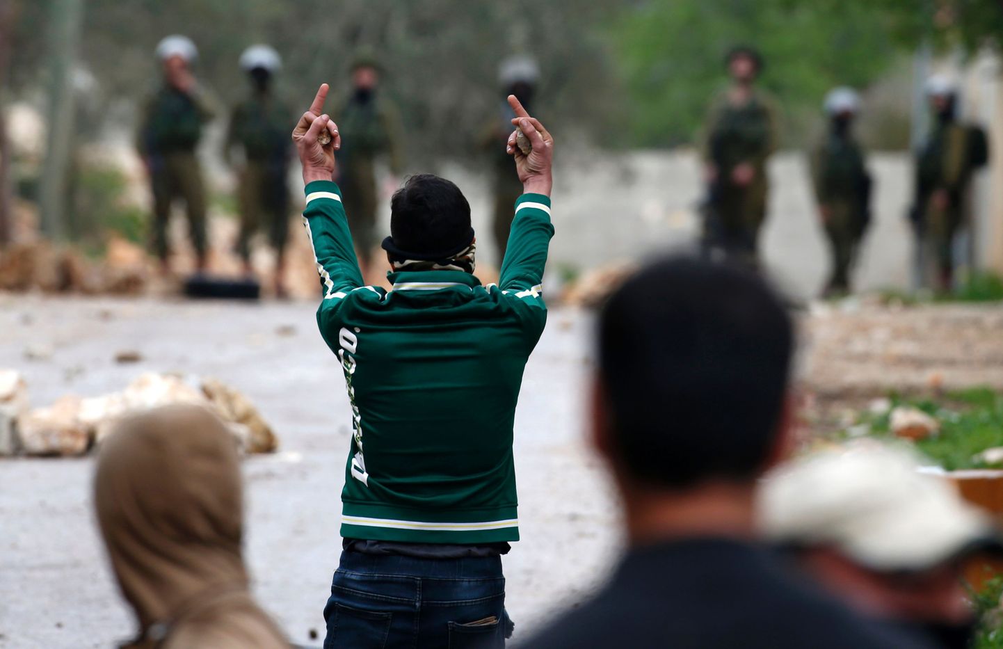 Paalestiina meeleavaldaja Iisraeli julgeolekuvägede suunas žestikuleerimas.