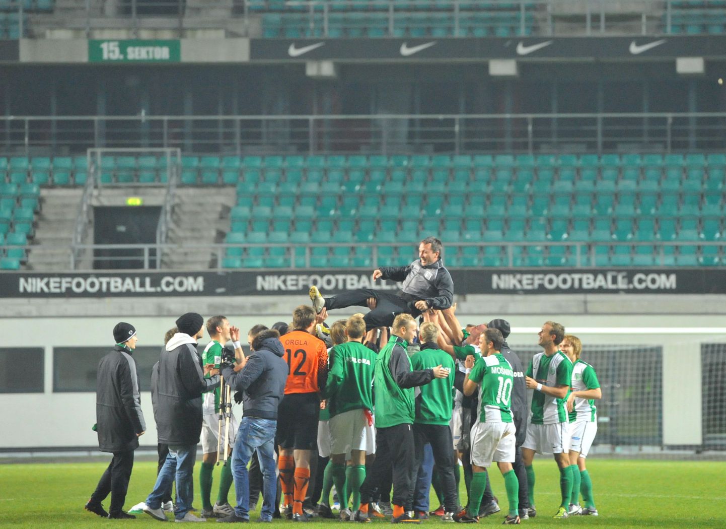 FC Flora mängijad peatreenerit Martin Reimi tiitlivõidu puhul õhku viskamas.