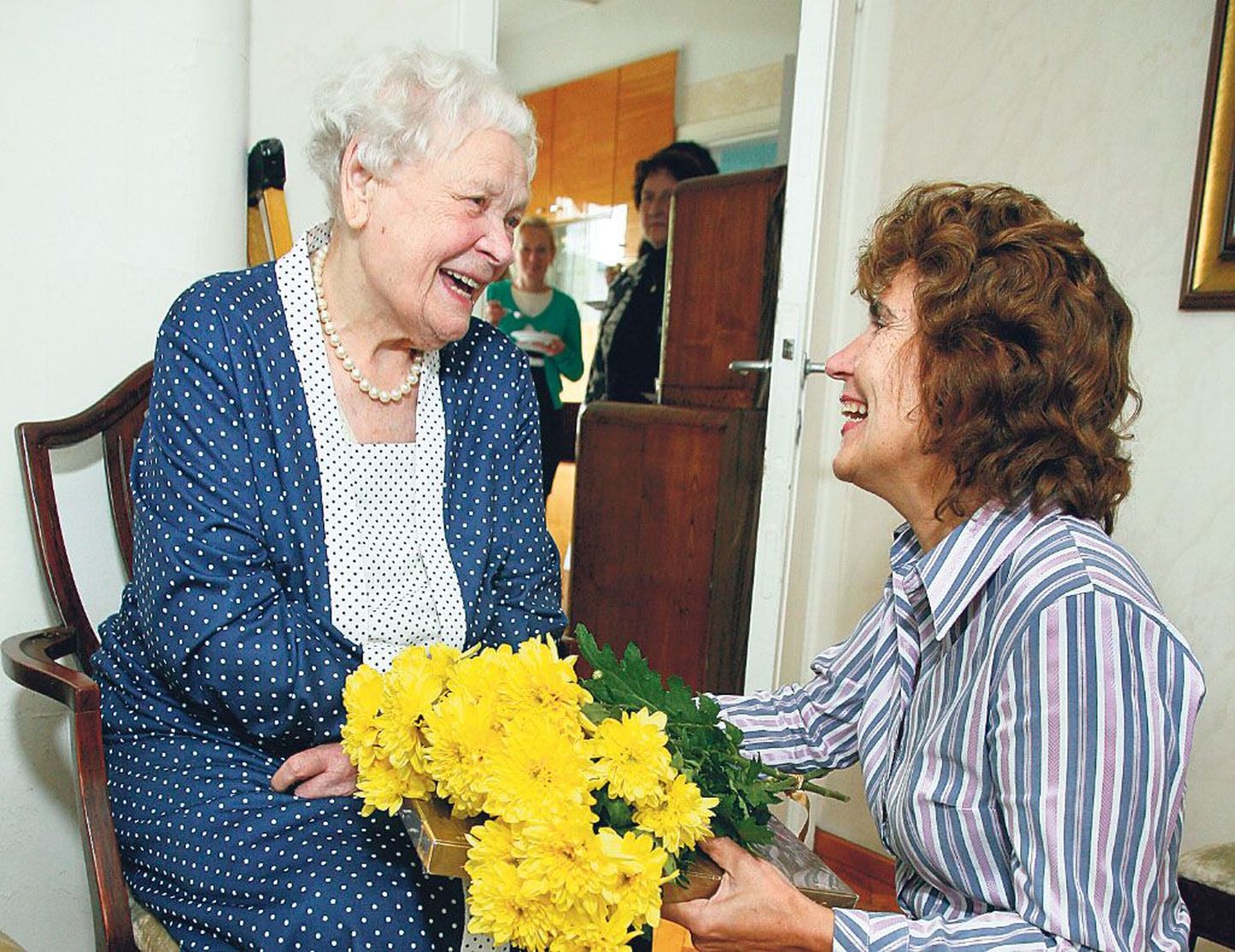 Pärnu abilinnapea Jane Mets ulatab lillekimbu saja-aastasele Ellen Lepikule.