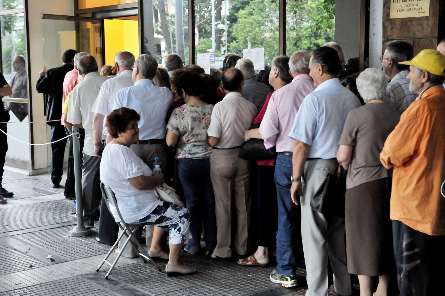 Kreeklased pangaautomaadi taga järjekorras.
