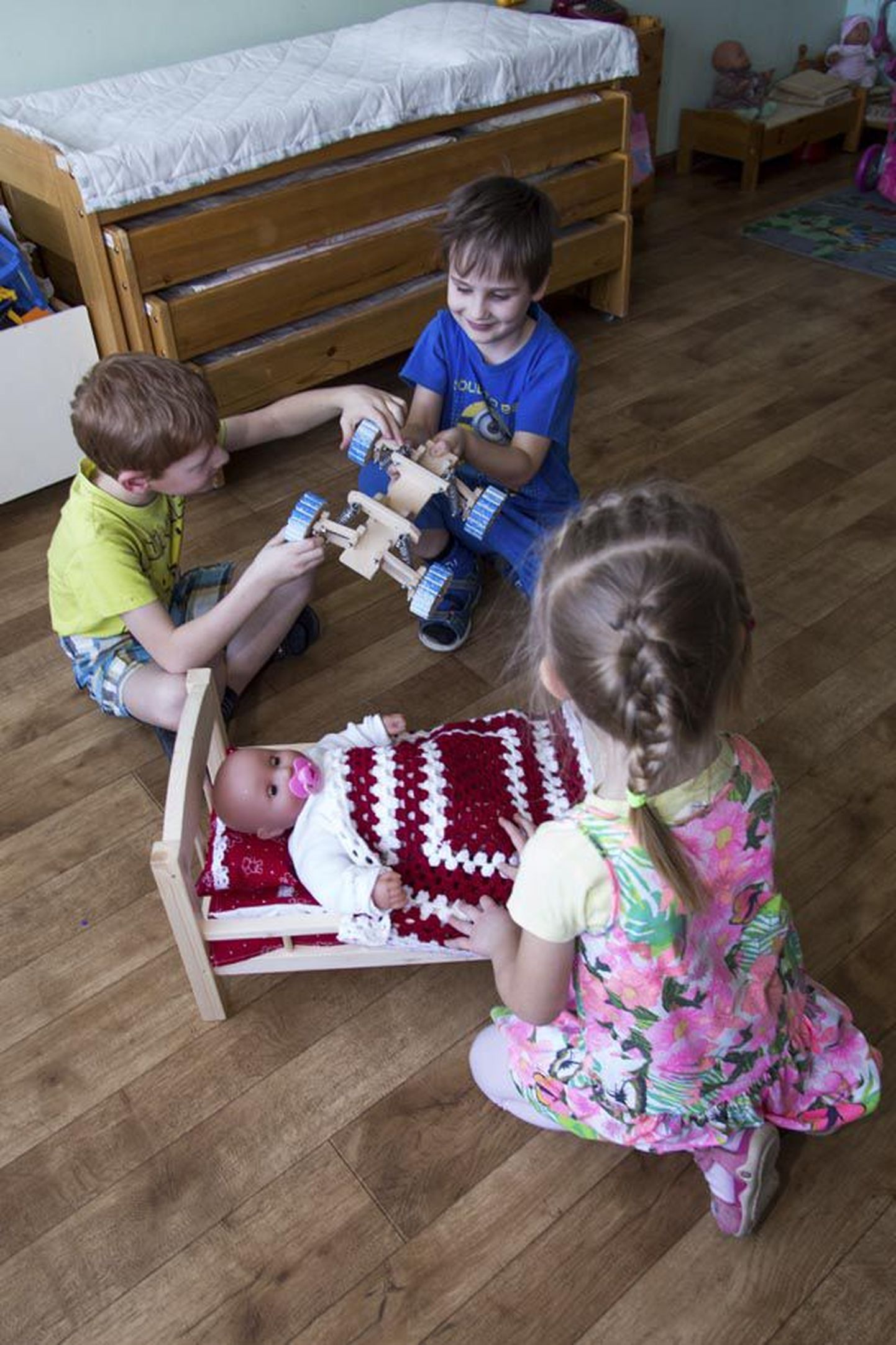 Männimäe lasteaia kasvandikud (vasakul) Robert, Märt ja Anni lustivad uute mänguasjadega.