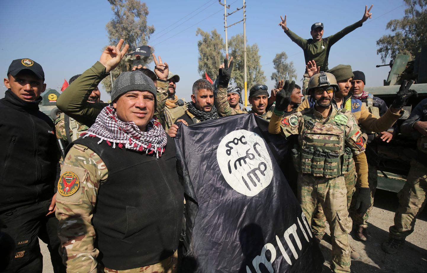 Iraagi sõjaväelased poseerimas ISISe lipuga.