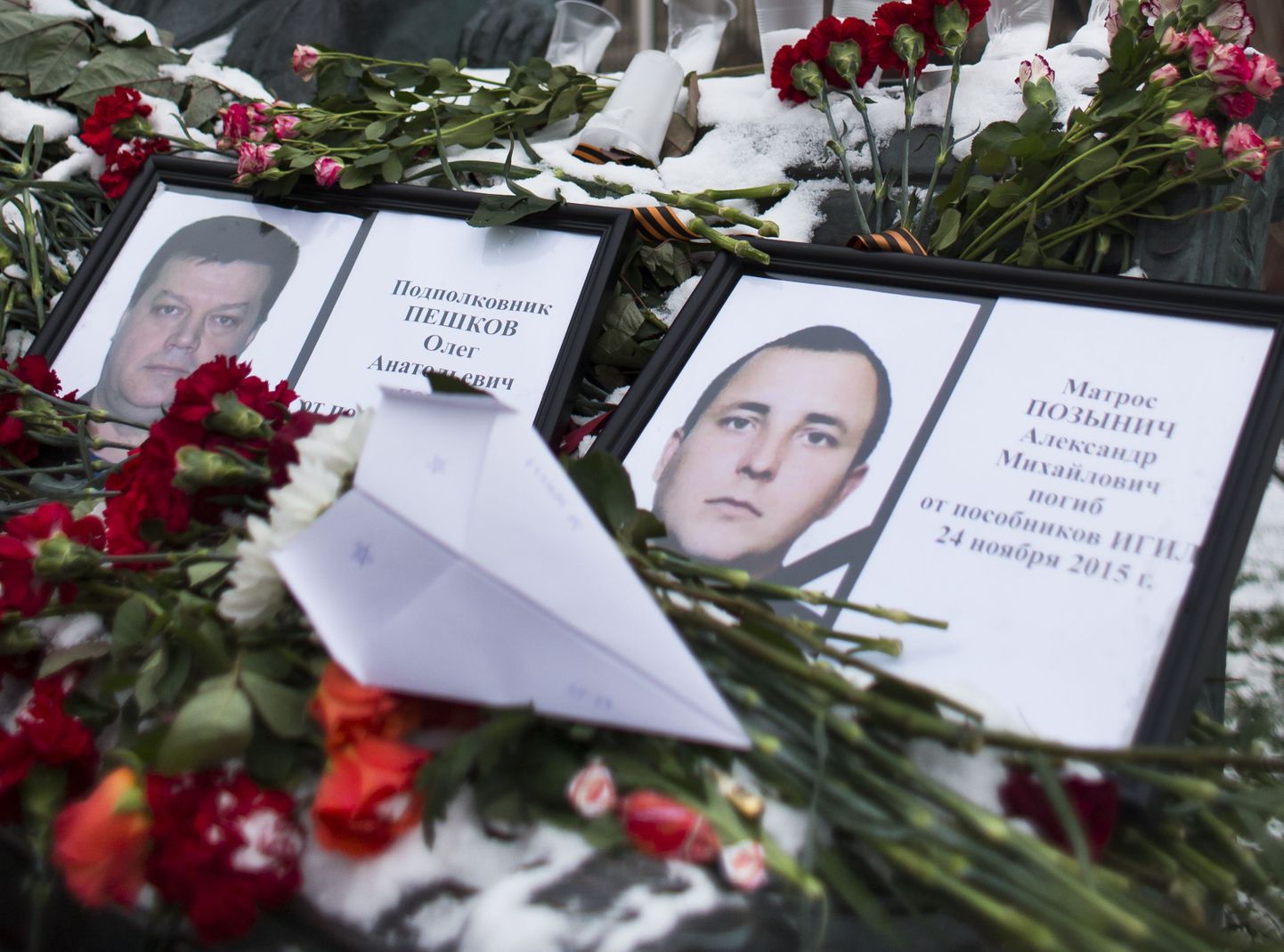 Oleg Peškovi (vasakul) ja erioperatsiooni käigus surma saanud Vene sõduri Aleksandr Pozõnitši pildid ja nende mälestuseks toodud lilled ohvitseride monumendi juures Moskvas.