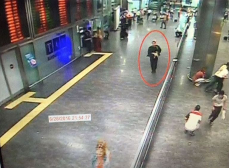 Pilt mehest, kes arvatakse olevat üks ründajatest ringi kõndimas lennujaama rahvusvahelises terminalis relvaga. Samal ajal on näha, kuidas inimesed peitu jooksevad.  