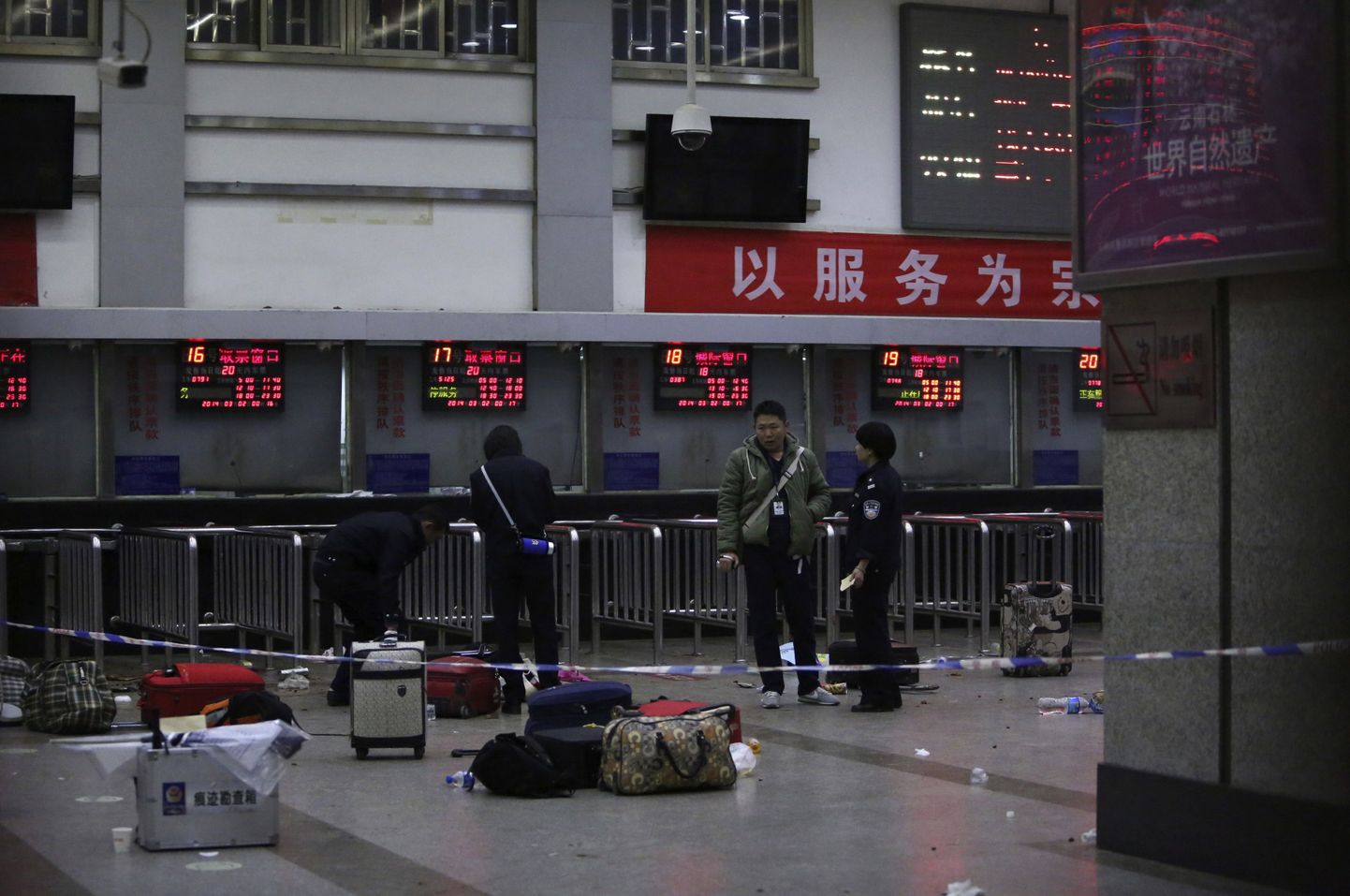 Police stand near luggages left at the ticket office after a group of armed men attacked people at Kunming railway station, Yunnan province, March 2, 2014. At least 27 people have been killed in the "violent attack" at the train station in Kunming carried out by a group of unidentified people brandishing knives, the Chinese state news agency Xinhua said on Sunday. Another 109 were injured, the report added. It said the attack had taken place late on Saturday evening. REUTERS/Stringer (CHINA - Tags: CIVIL UNREST CRIME LAW TPX IMAGES OF THE DAY) CHINA OUT. NO COMMERCIAL OR EDITORIAL SALES IN CHINA