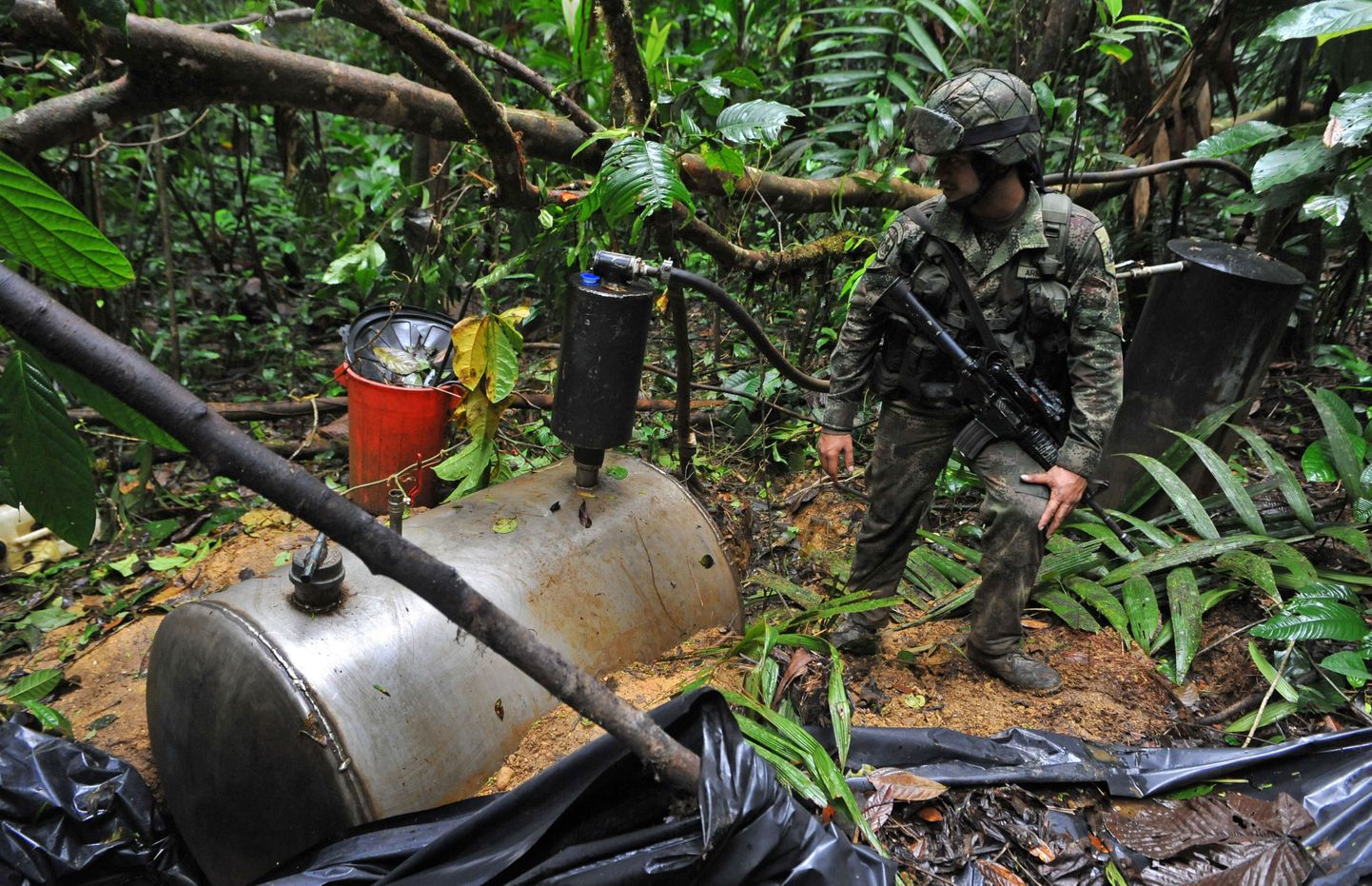 Kolumbia sõdur vedela kokaiini kanistri juures.