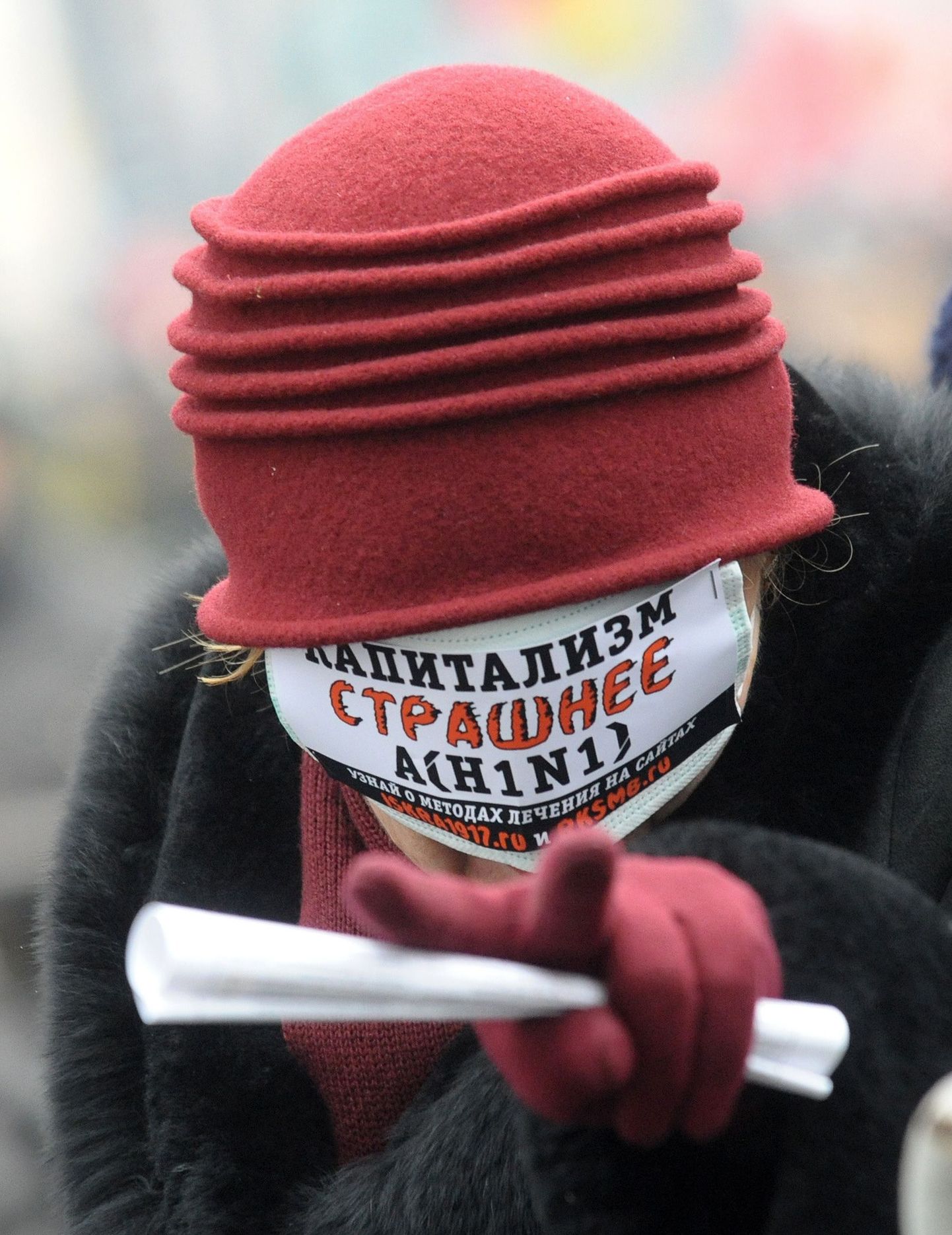 Kommunistide toetaja Moskvas oktoobrirevolutsiooni aastapäeval näomaskiga, millel seisab: «Kapitalism on kahjulikum kui H1N1».