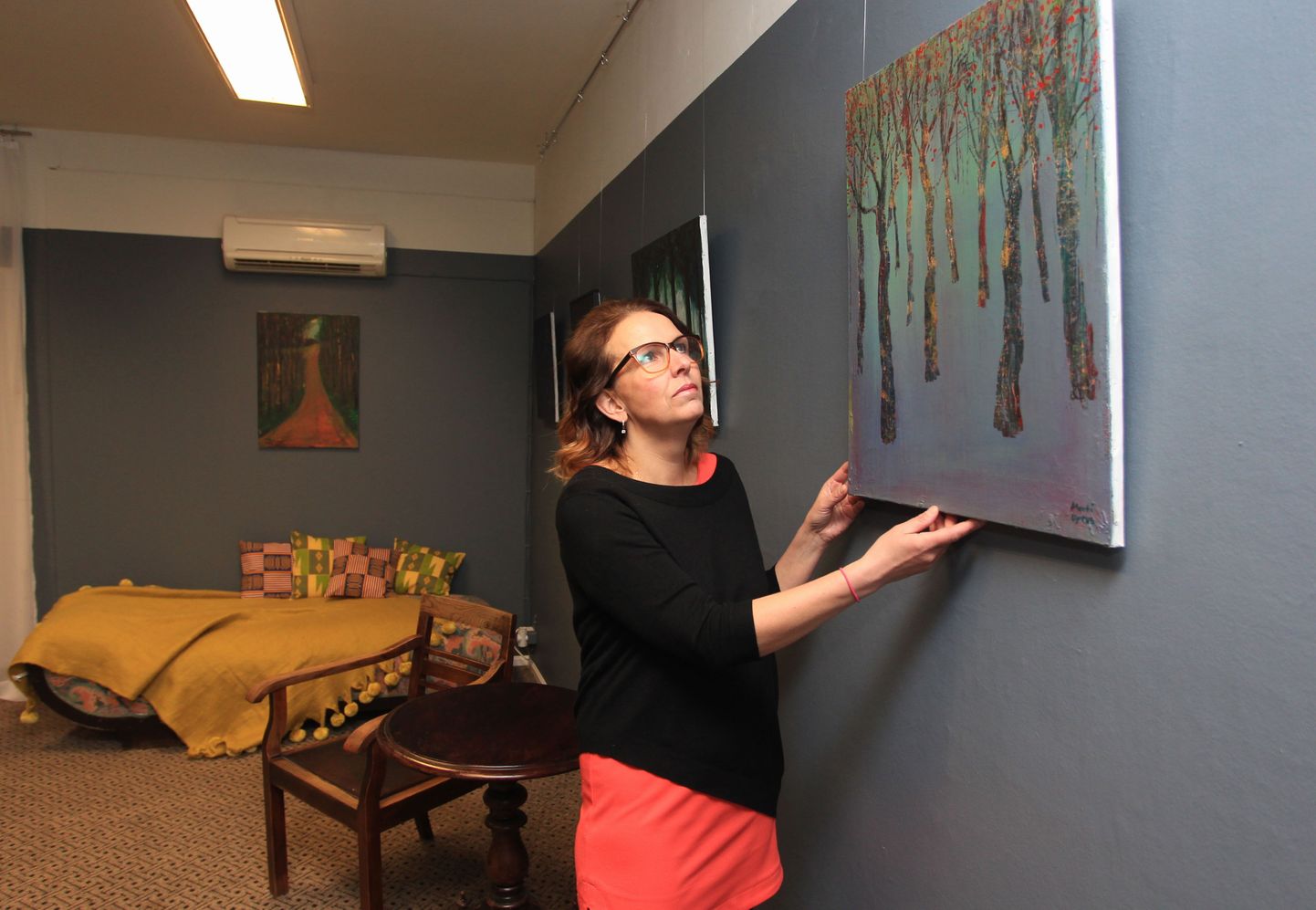 Marita Tani sätib oma ilusalongi Olga & Osvald (Tähe 22) nn elutoas paika pilti, mis kuulub 
kunstnik Mati Upruse maalide väljapanekusse.