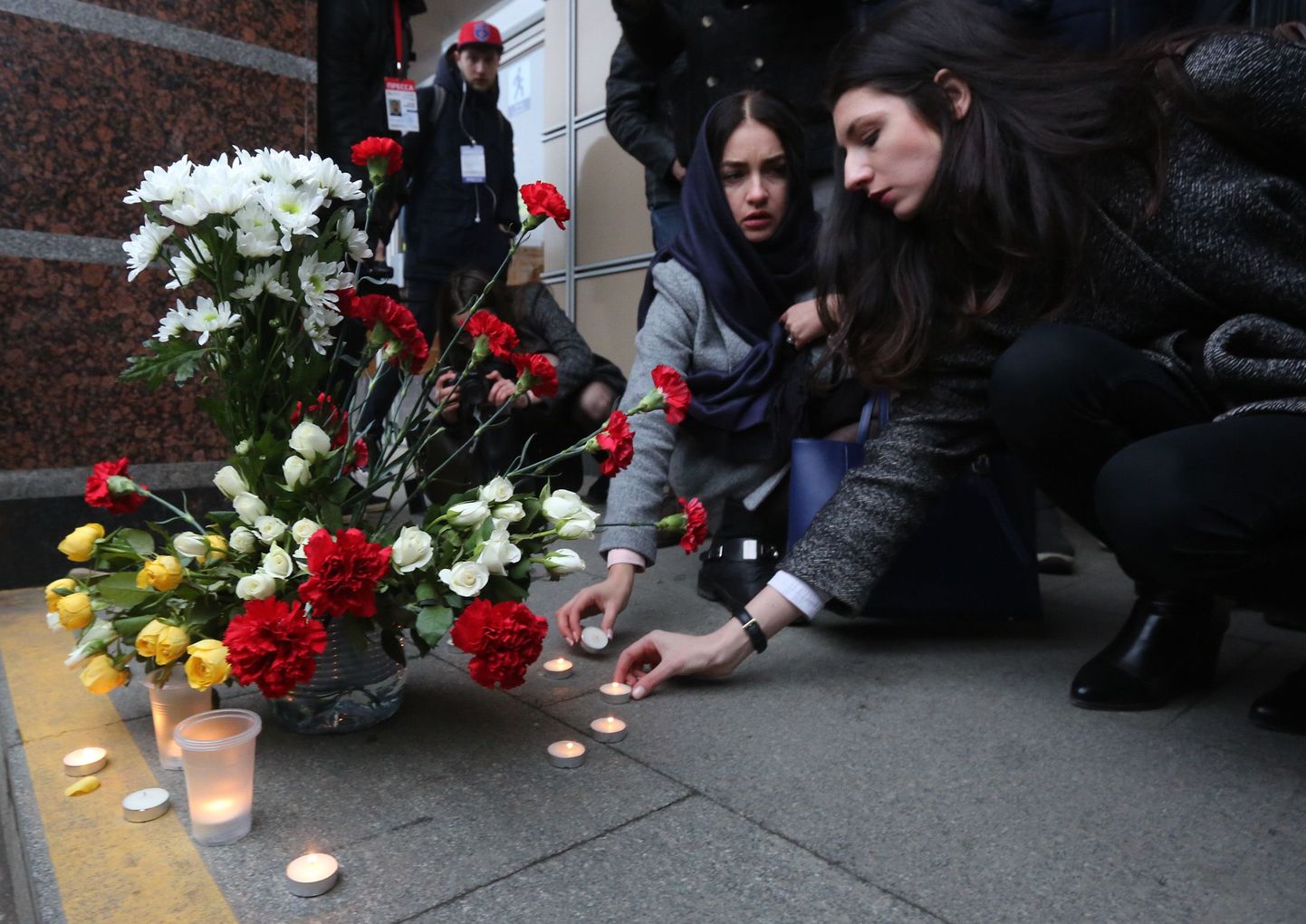 Люди несут цветы, чтобы почтить память жертв теракта в Санкт-Петербурге.