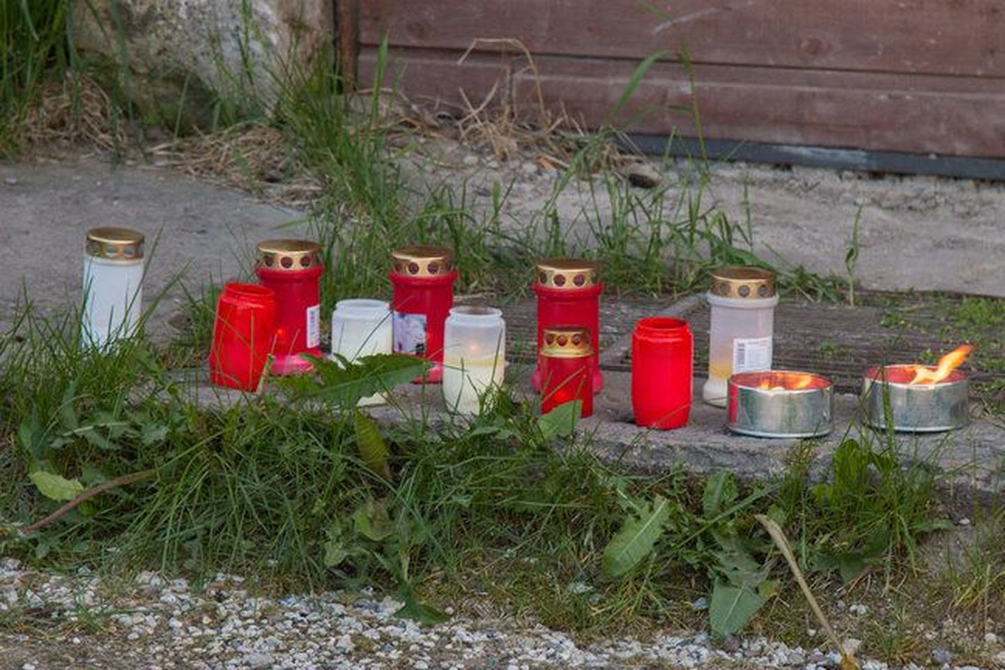 К дому, где был убит молодой человек, приносят траурные свечи.