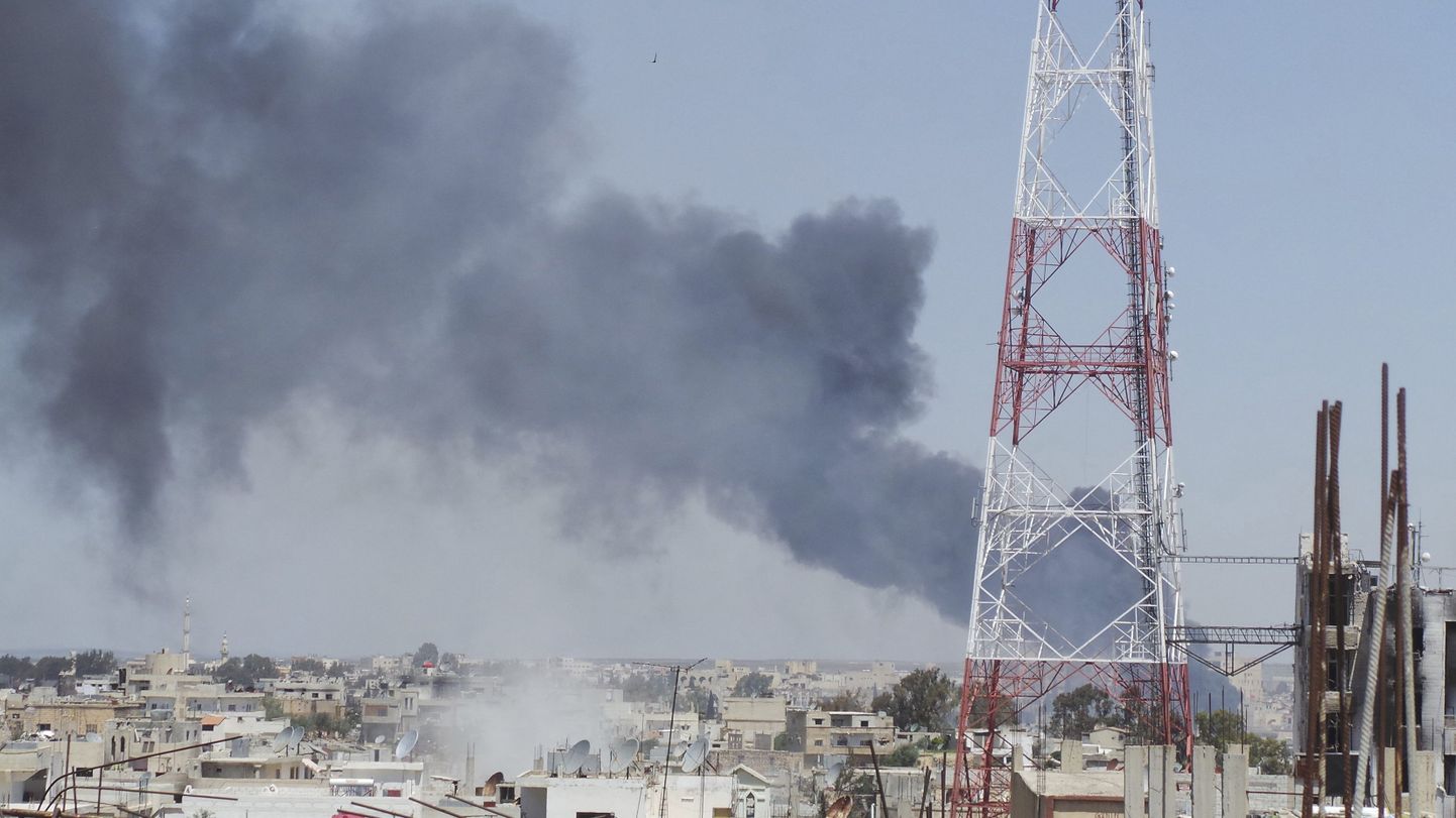 Suits Dera linna kohal, mis tõuseb aktivistide andmetel Süüria lennuväe tulistatud mürsutabamuse järel.