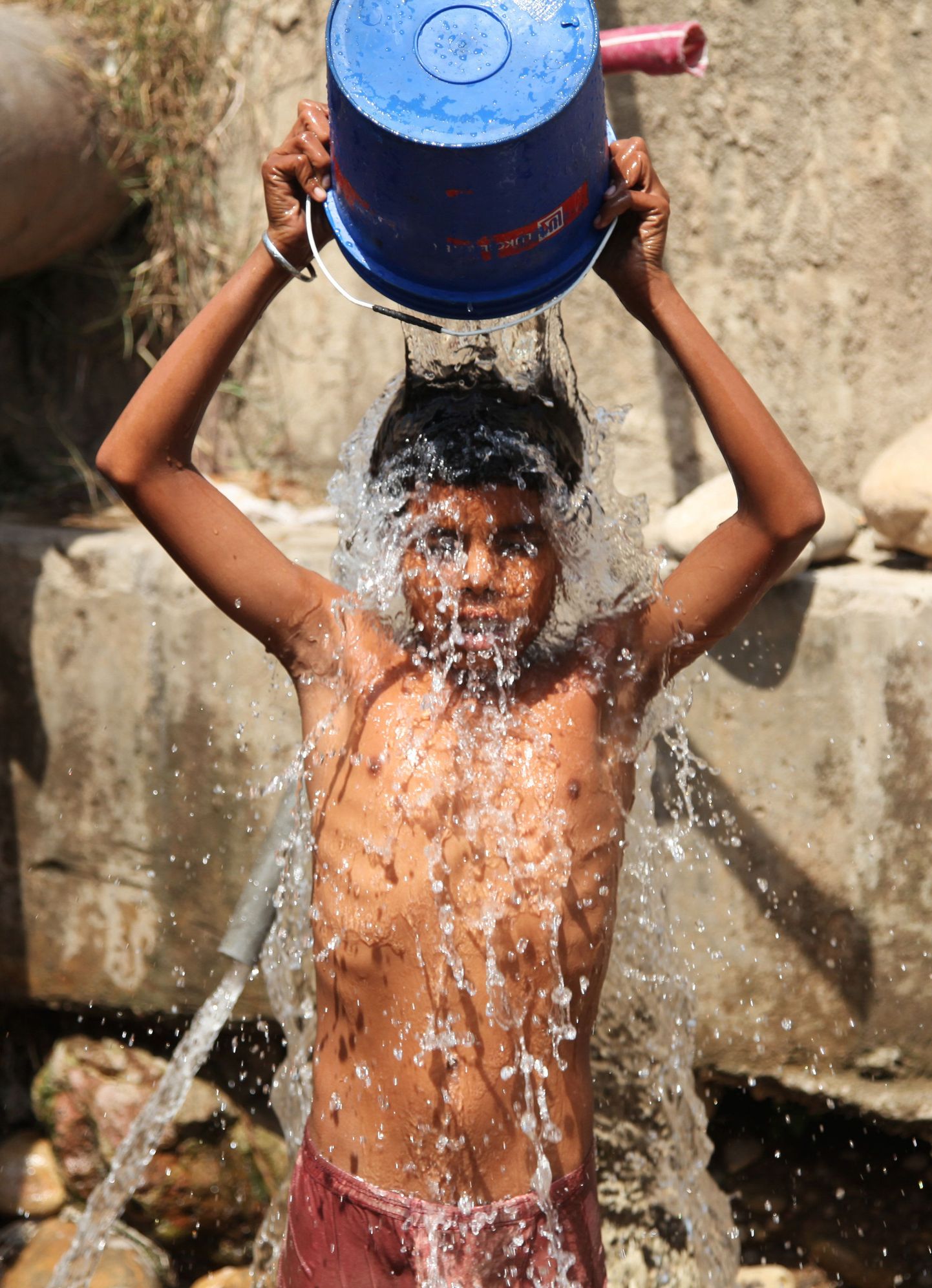 Мальчик спасается от аномальной жары в Индии.