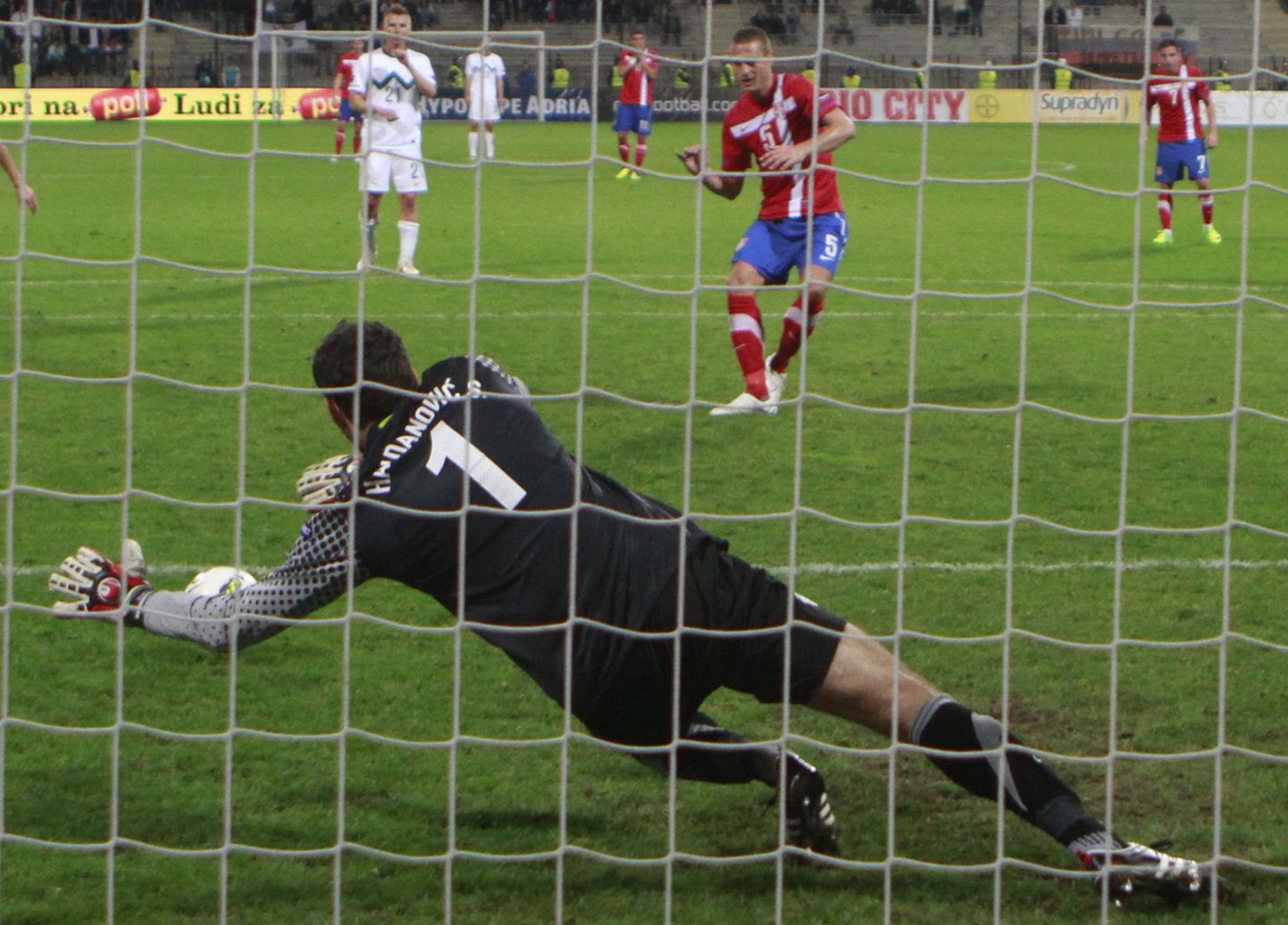 Sloveenia väravavaht Samir Handanovic tõrjub Nemanja Vidici penalti.