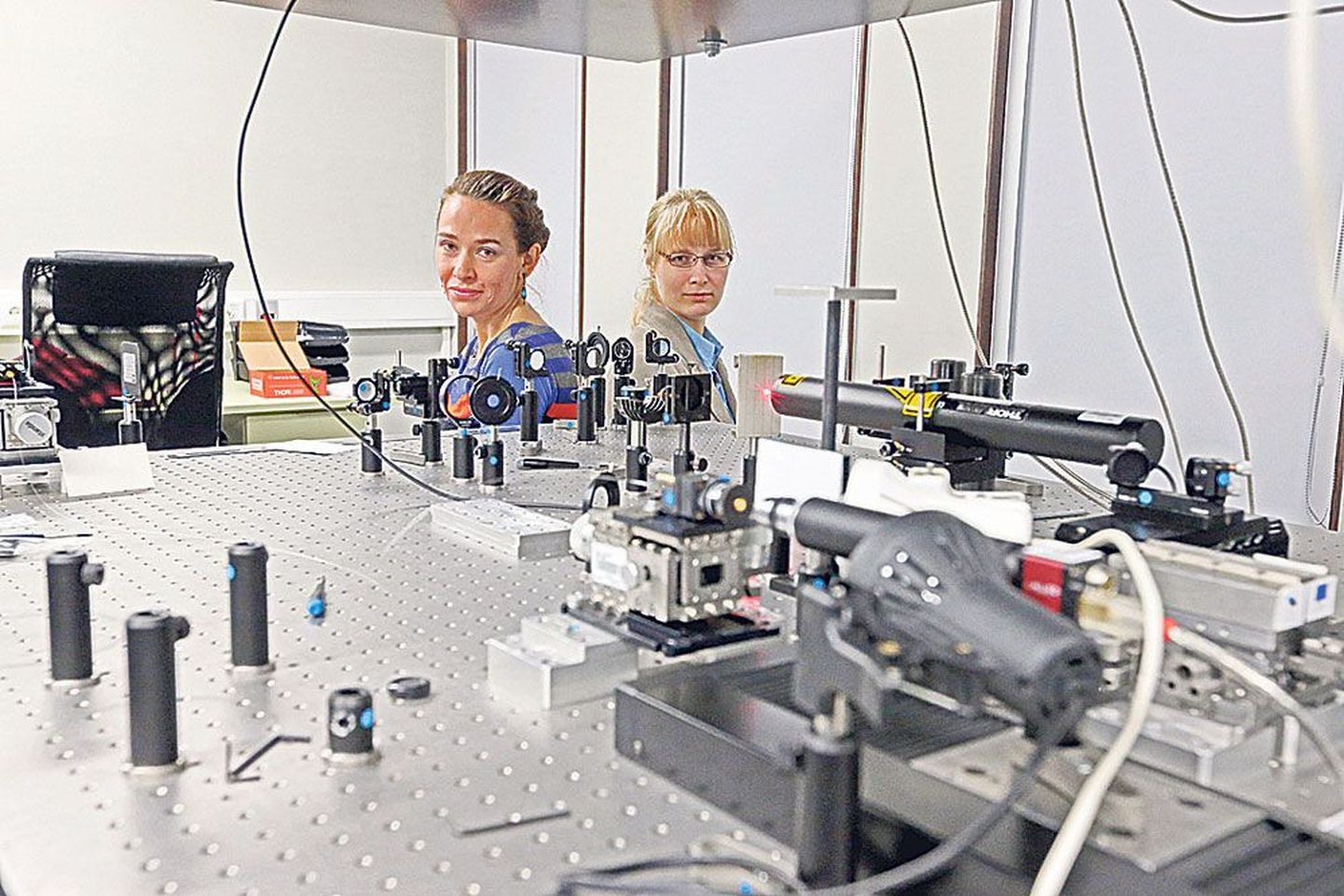 Riin Tamm (vasakul) ja Heli Lukner ei tööta külg külje kõrval küll Phy­sicumis füüsikalise optika laboris, kus see pilt on tehtud, vaid hoopis noorte teadussaates «Rakett 69» kohtunikena.
