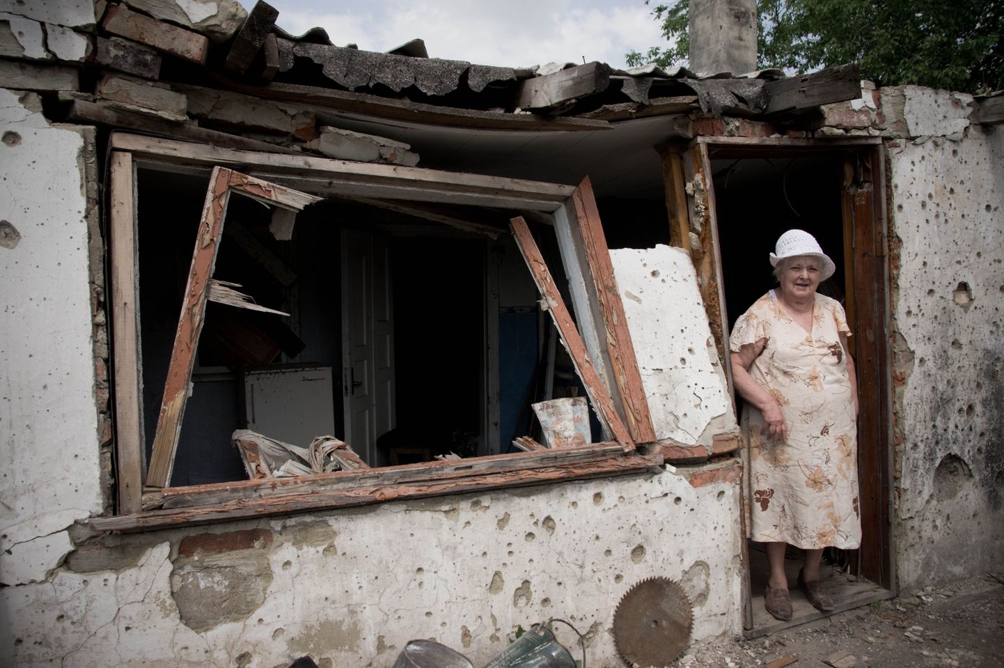 Ida-Ukraina elanik pommirünnakus hävinud kodu ees.