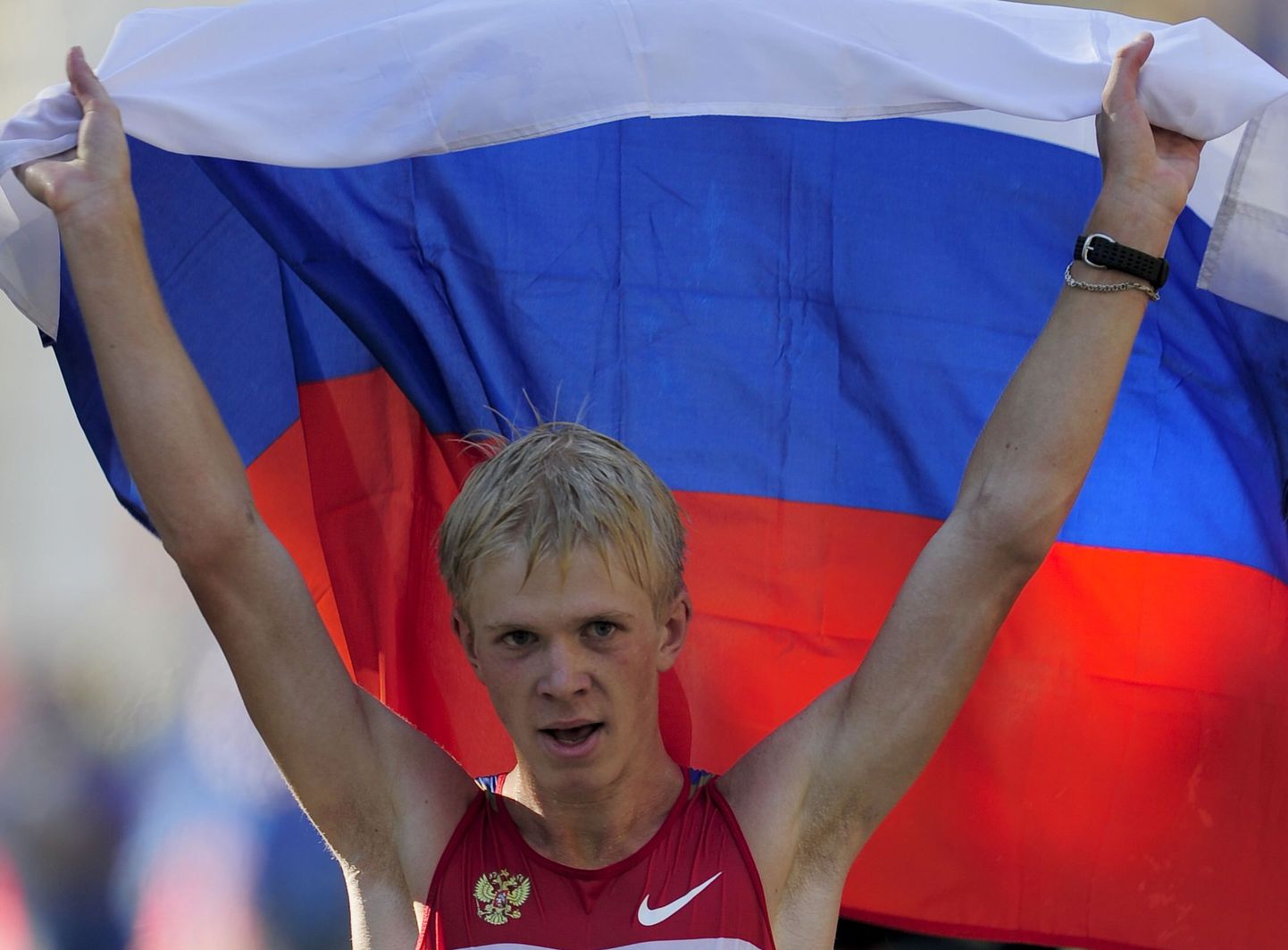 Russia's Stanislav Emelyanov celebrates with a russian flag after winning the men's 20km walk at the 2010 European Athletics Championships at the Olympic Stadium in Barcelona on July 27, 2010.    AFP PHOTO / JOSEP LAGO