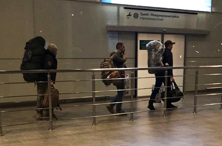 Neidentificēti vīrieši pēc izkāpšanas no lidmašīnas Rostovas lidostā Krievijā. Rokās viņiem maisiņi no Damaskas lidostas "duty free" zonas. 