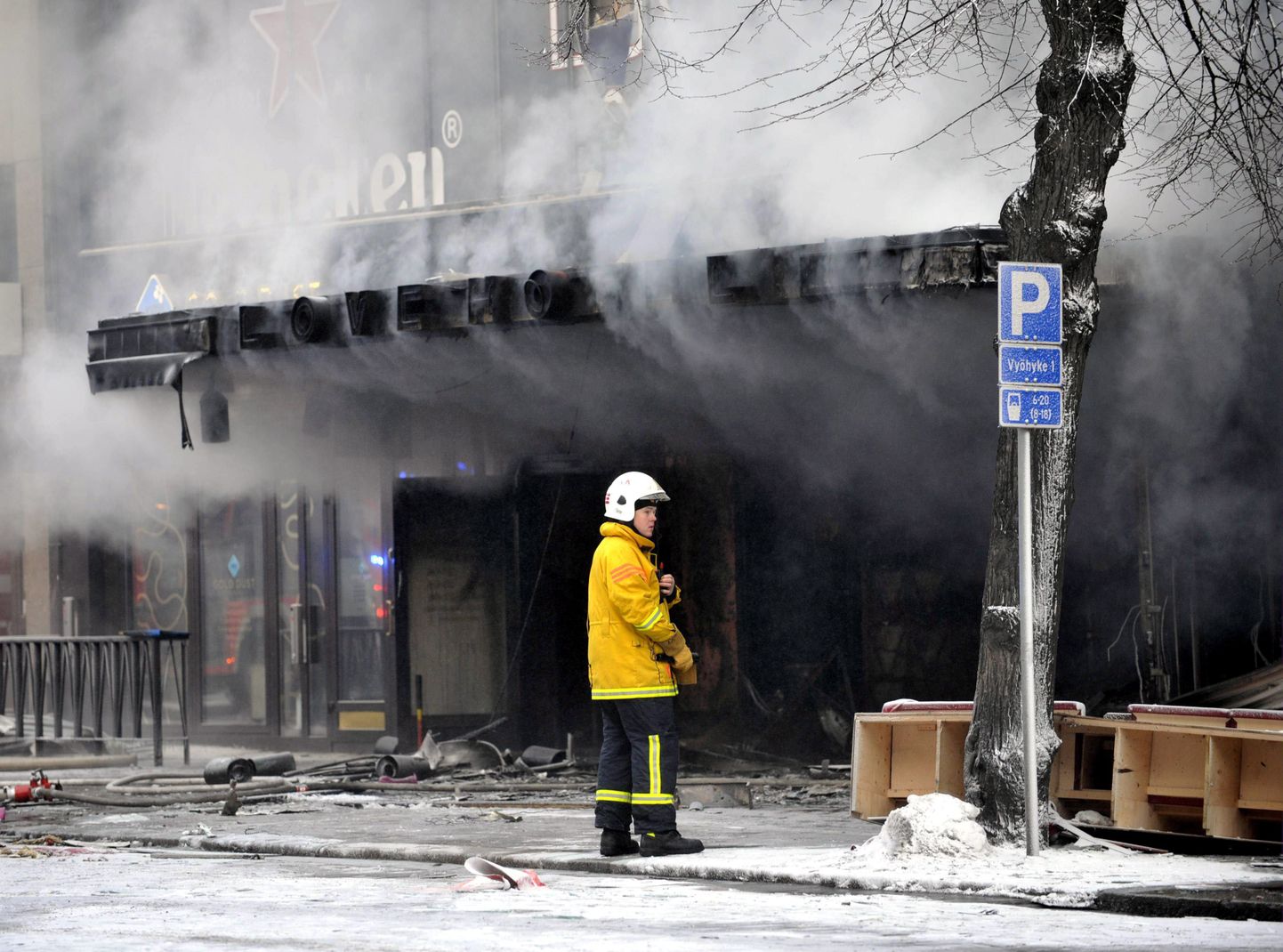 Soome tuletõrjuja Tampere kesklinnas põlenud maja ees.