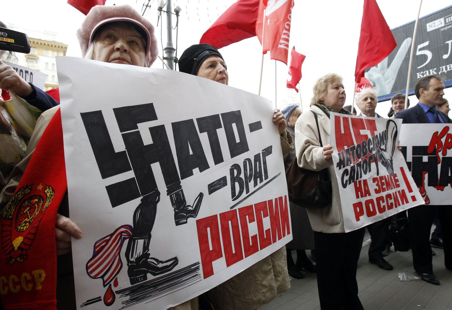 Kommunistliku Partei liikmed avaldamas meelt NATO vastu. Allianssi kujutatakse vasakpoolsel plakatil Venemaa vaenlasena ja natside ühendusena.