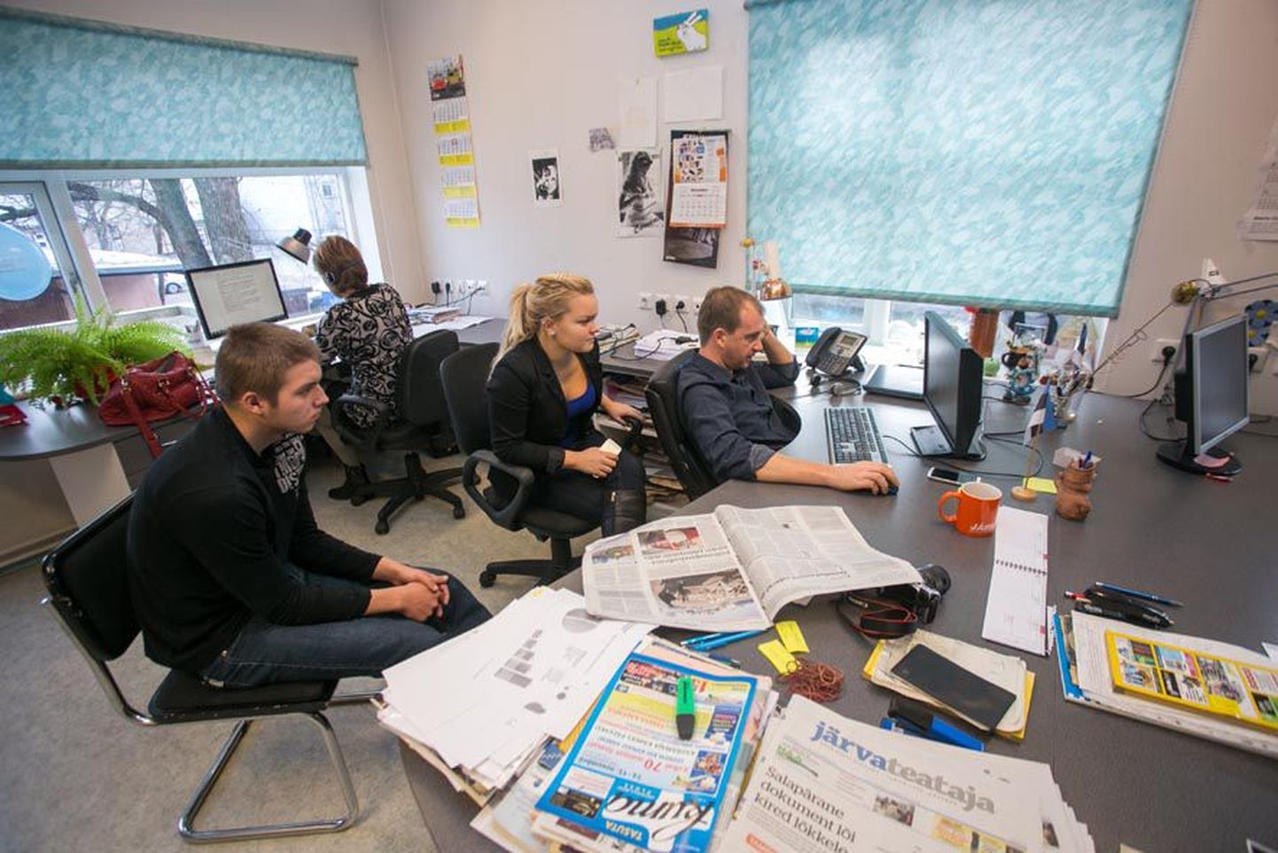 Järva Teataja ajakirjanik Tiit Reinberg näitab Romet Luugile ja Kimberly Jakobsonile kuidas jõuavad uudised digilehte.