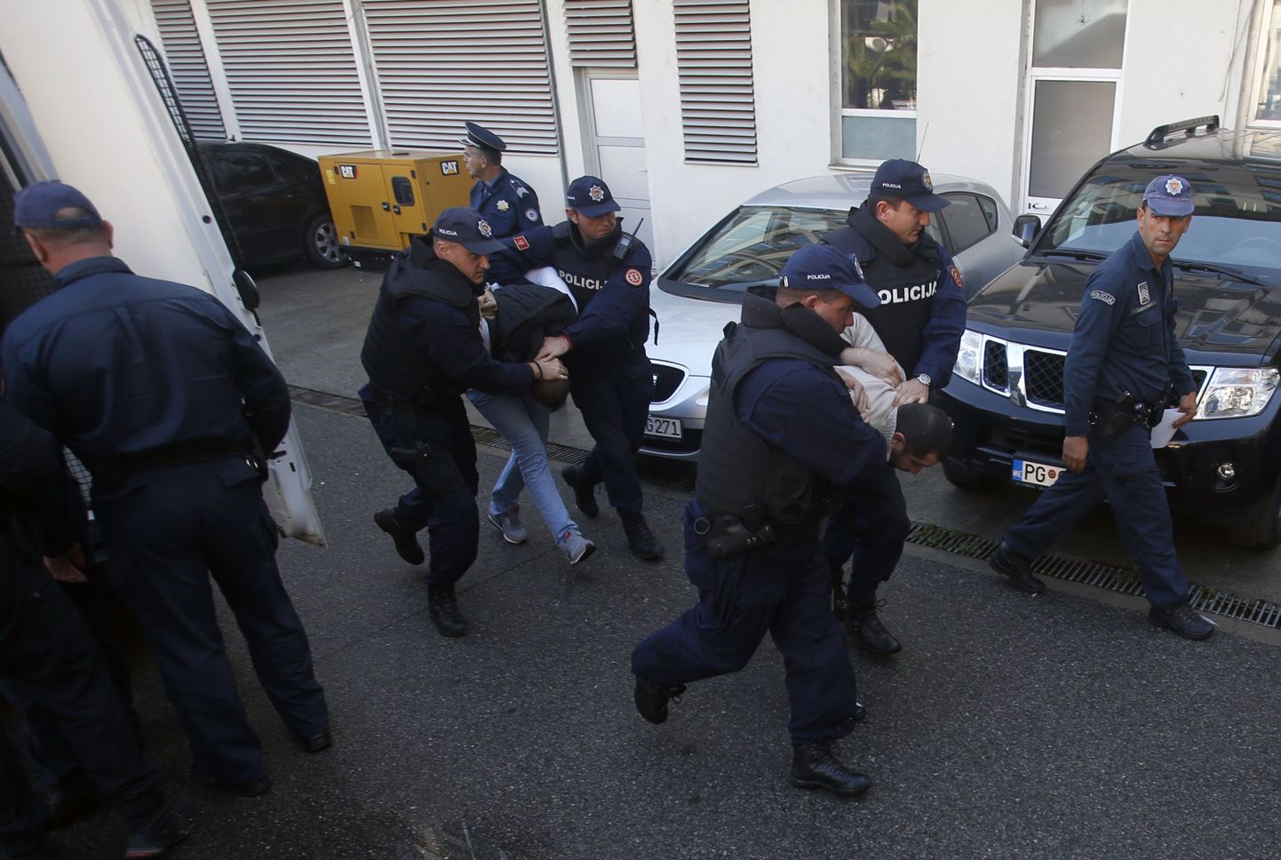 Полиция Черногории эскортирует подозреваемых в перевороте.