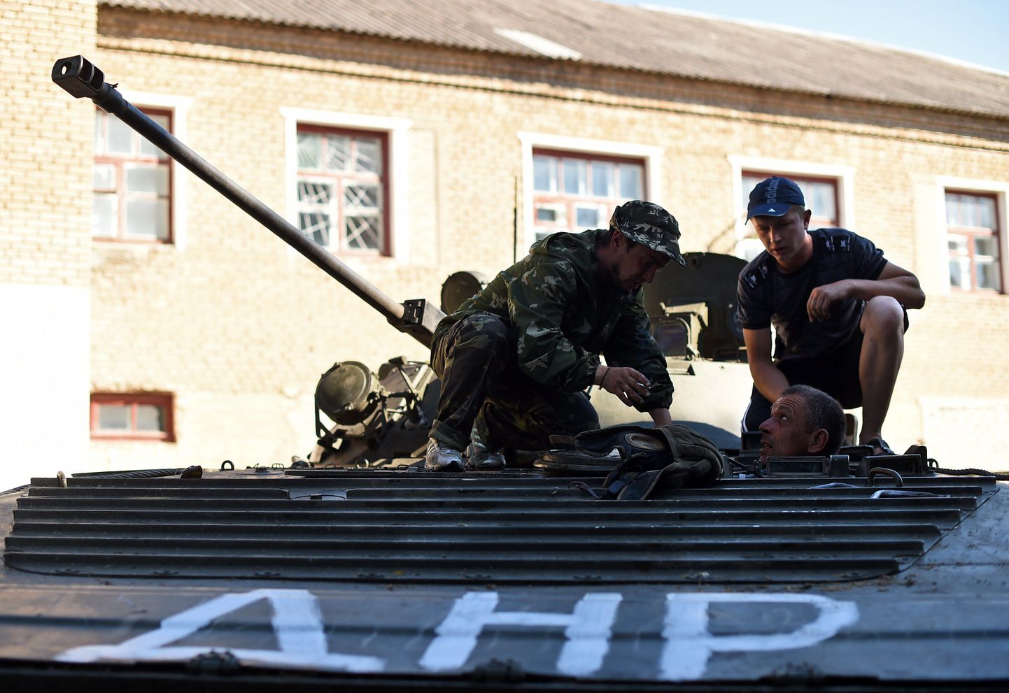 Сепаратисты пытаются починить захваченный у украинских военных танк.