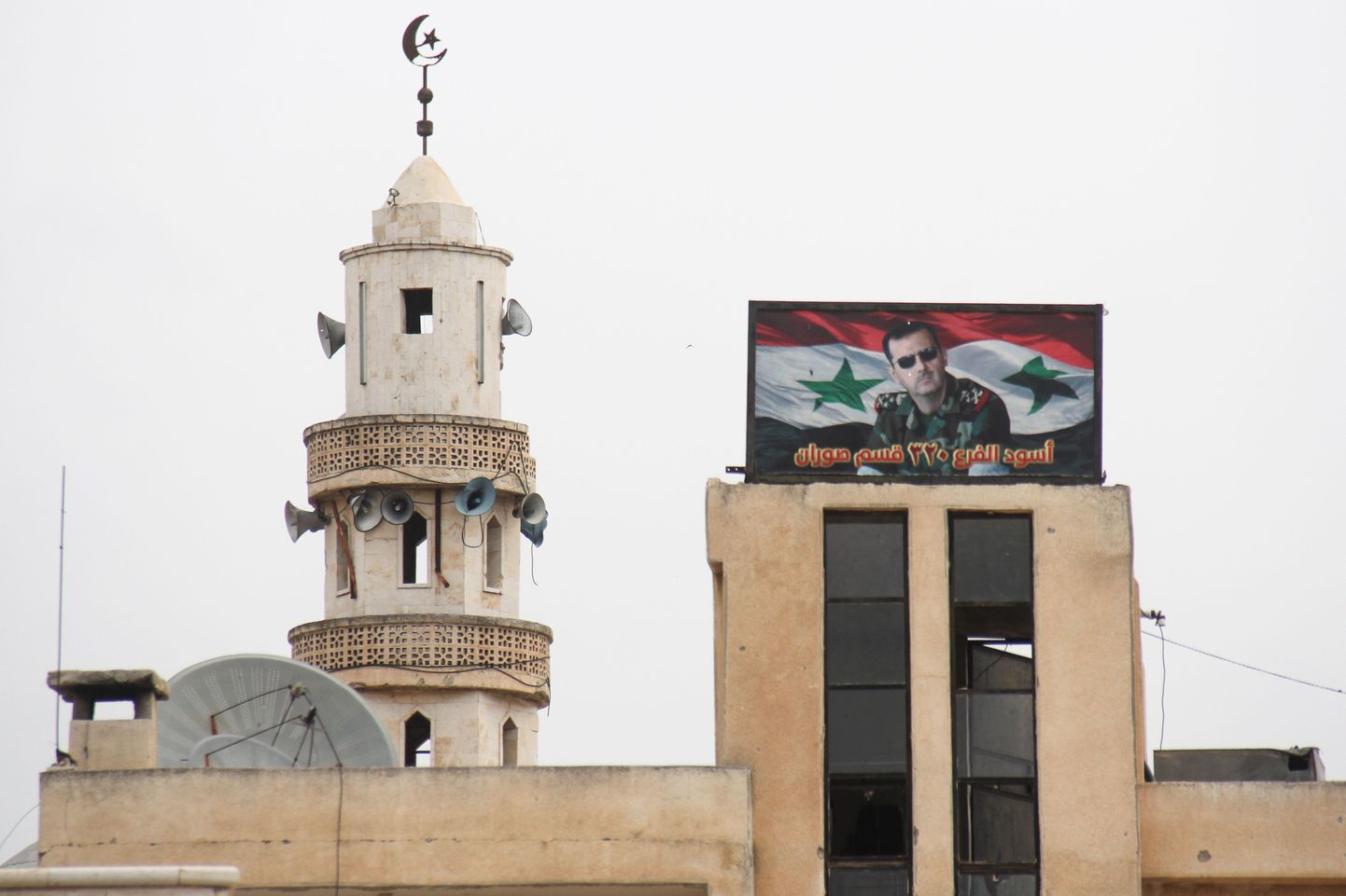 Plakat Surani linnas, mis kujutab president Bashar al-Assadi kandmas maskeerimisülikonda ja päikeseprille.