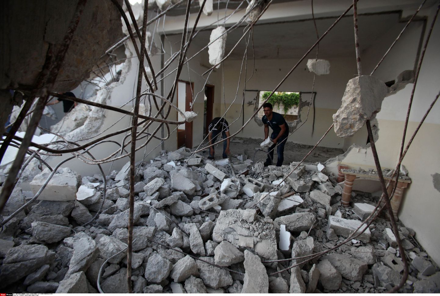 Palestiinlased oma kodu varemeid koristamas
