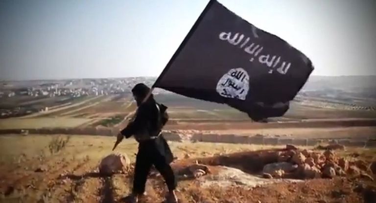 ISISe võitleja terrorirühmituse lipuga. 