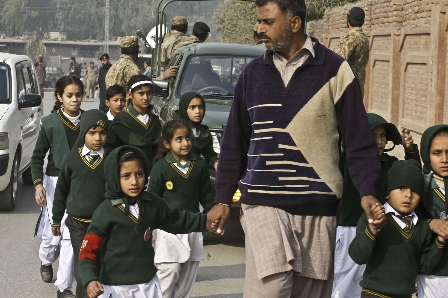 Erariides julgeolekuametnik täna Peshawaris õpilasi kooli territooriumilt välja toimetamas.