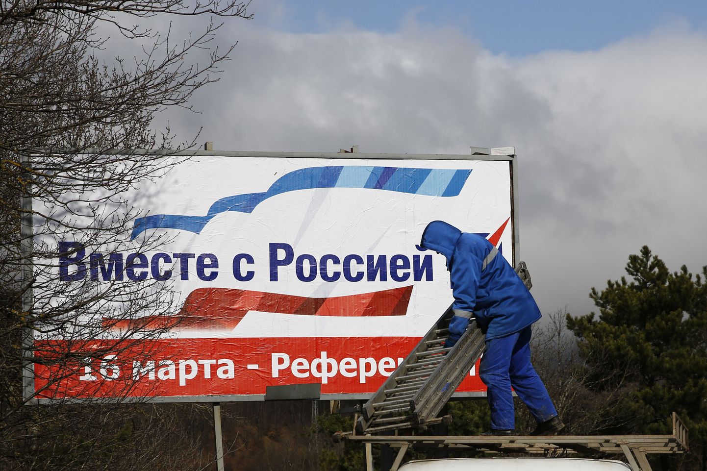 Mees paneb Simferopoli lähistel üles plakatit, kus näidatakse inimestele, et referendumil tuleb hääletada Venemaaga ühinemise poolt.