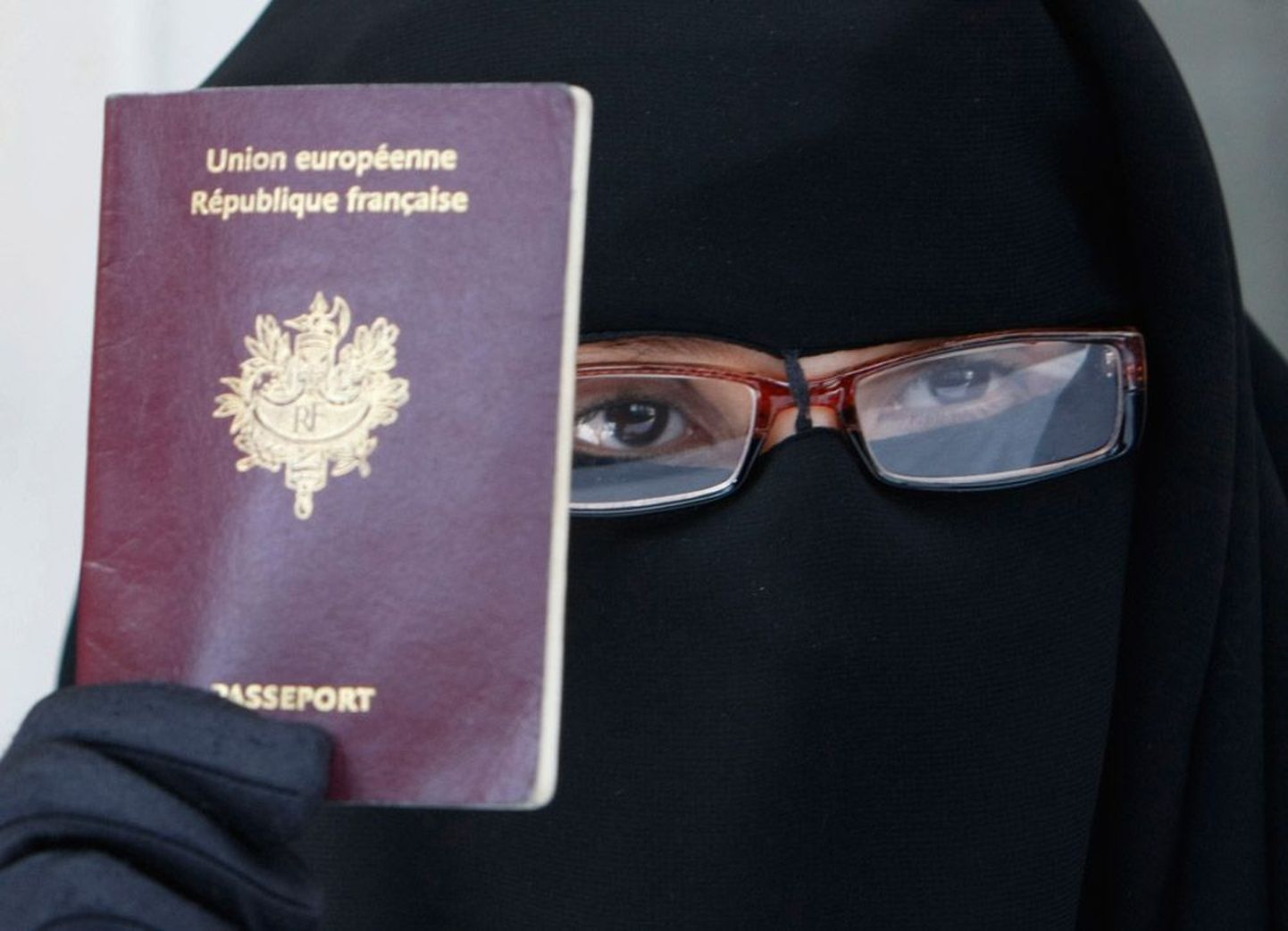 Женщина в никабе с французским паспортом. По мнению правительства Франции, запрет на ношение бурки и никаба направлен на то, чтобы обеспечить равенство и защитить женщин от унижений. Противники же считают эту кампанию политической.