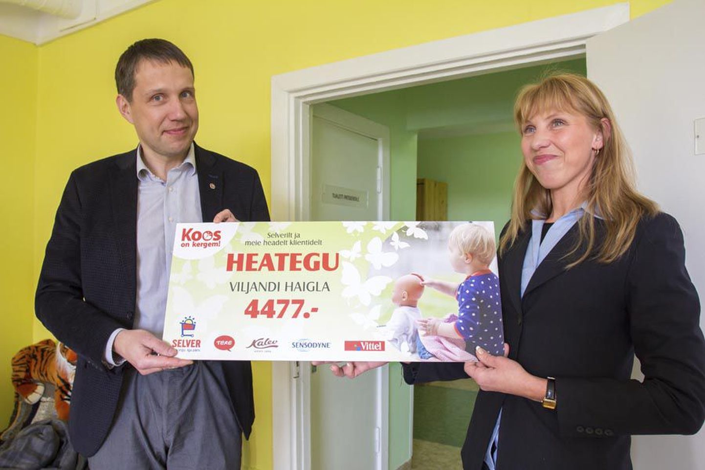 Männimäe Selveri juhataja Kati Pell (paremal) ulatab annetatud summaga tšeki Viljandi haigla juhatuse esimehele Priit Tamperele. Raha läheb lastepsühhiaatria osakonnale.