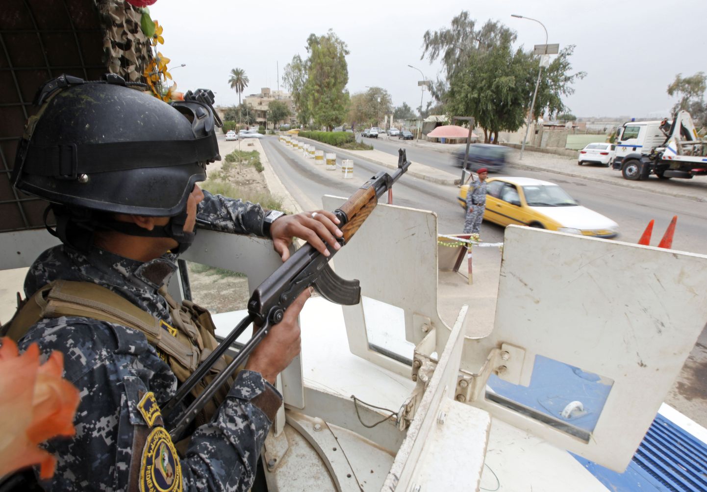Iraagi politseinik valvamas soomuki otsast korda Bagdadi kesklinnas.