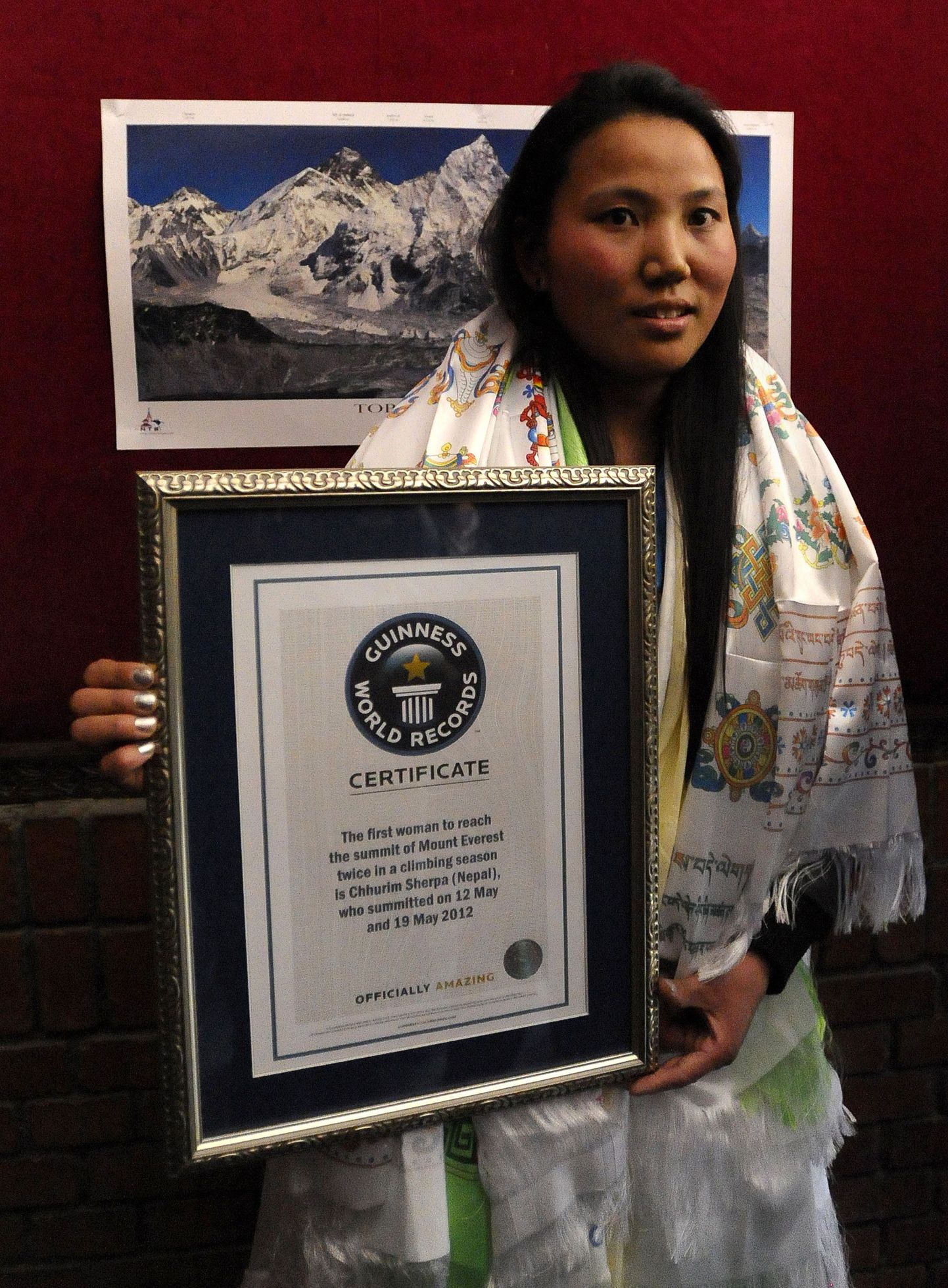 Nepali alpinist Chhurim Sherpa poseerib oma Guinnessi rekordi sertifikaadiga.