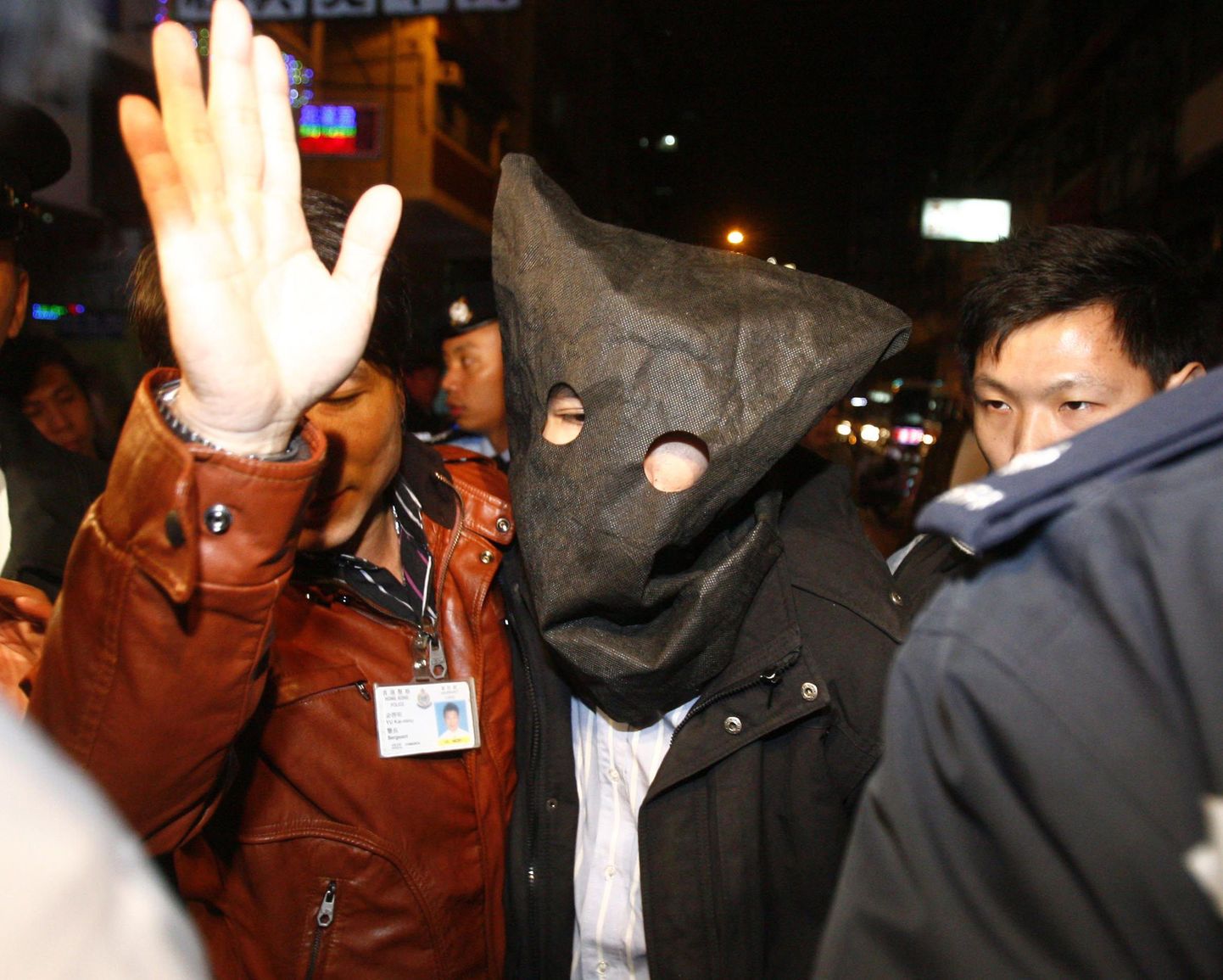 Hongkongi politsei eskortimas laupäevase happerünnaku järel vahistatud meest.