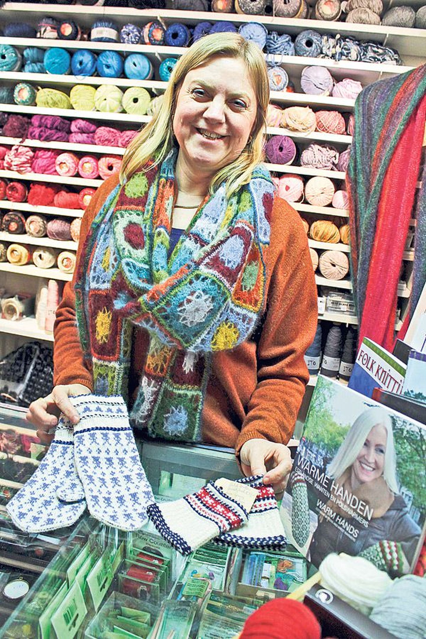 Amsterdami kesklinnas lõngapoes: müüja Carla Meijsen näitab Hollandi veskitega eesti stiilis kootud käpikuid. Letil on raamatud Eesti kudumisest.