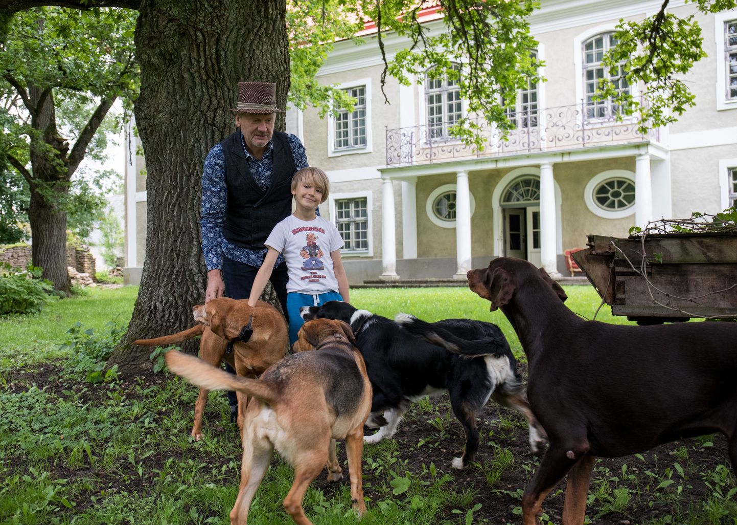 Mõisaomanik Erik Laansoo koos 6aastase tütrepoja Karl-Eriku ja koerakarjaga Ohtu mõisa ees iidse tamme all.
