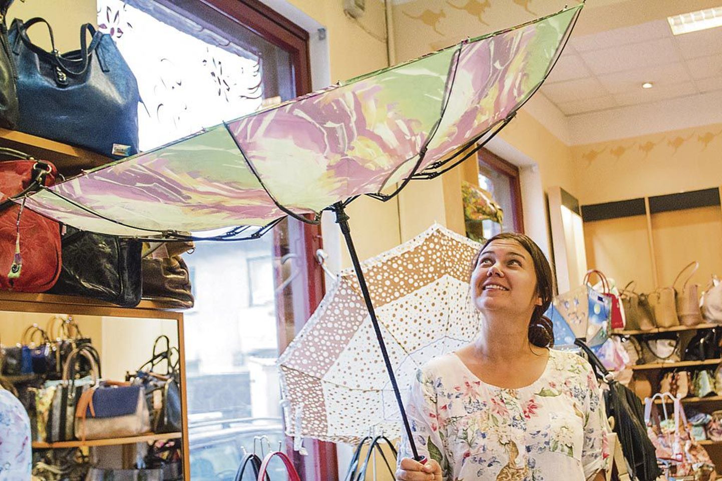 Klienditeenindaja Kerstin Soomets näitab uutmoodi tuulekindlat vihmavarju, mille plastosa kaardub, ilma et puruneks.