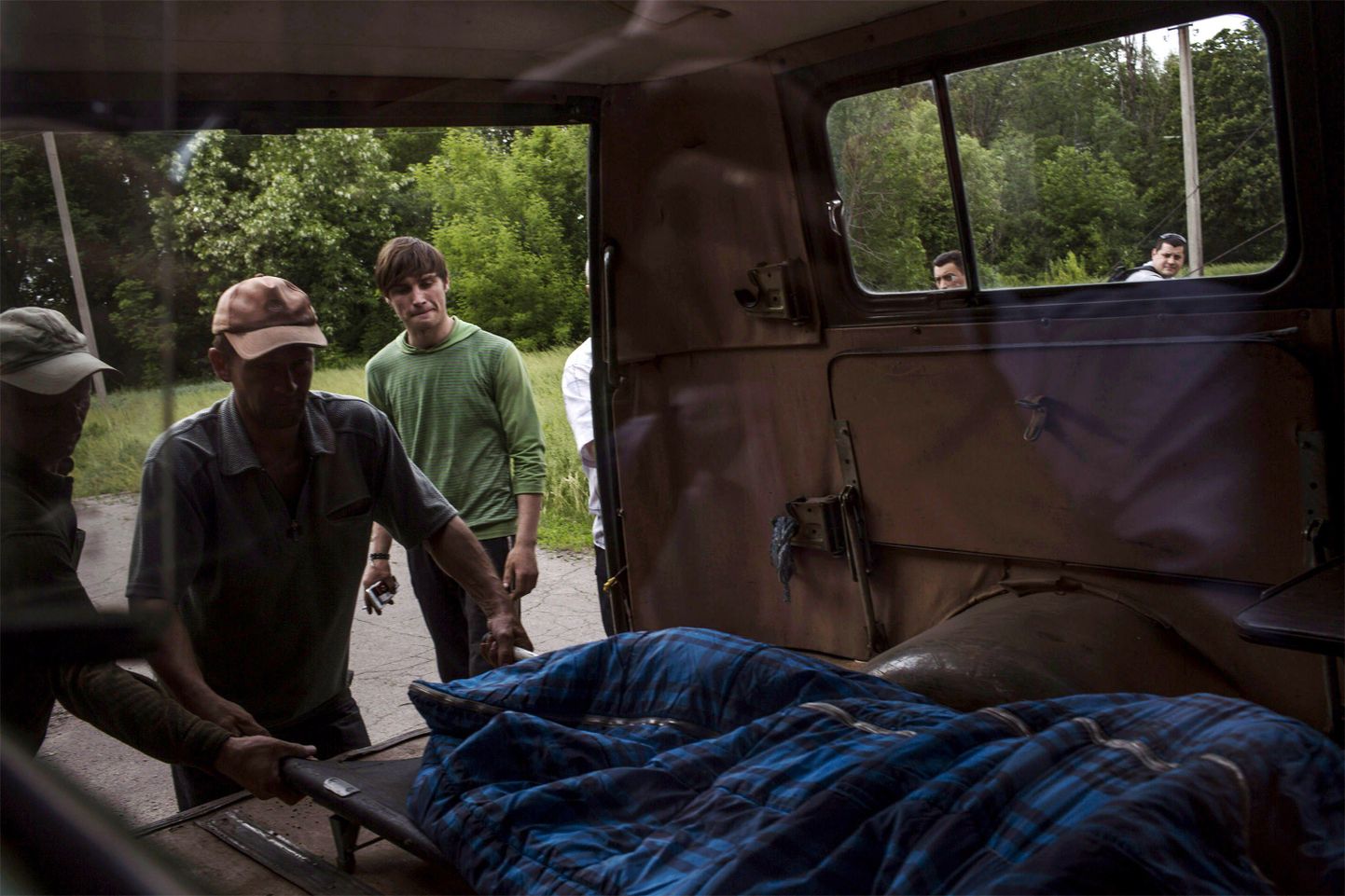 Kohalikud mehed aitasid tapetud Ukraina sõdurite maiseid jäänuseid surnukuuri toimetada.